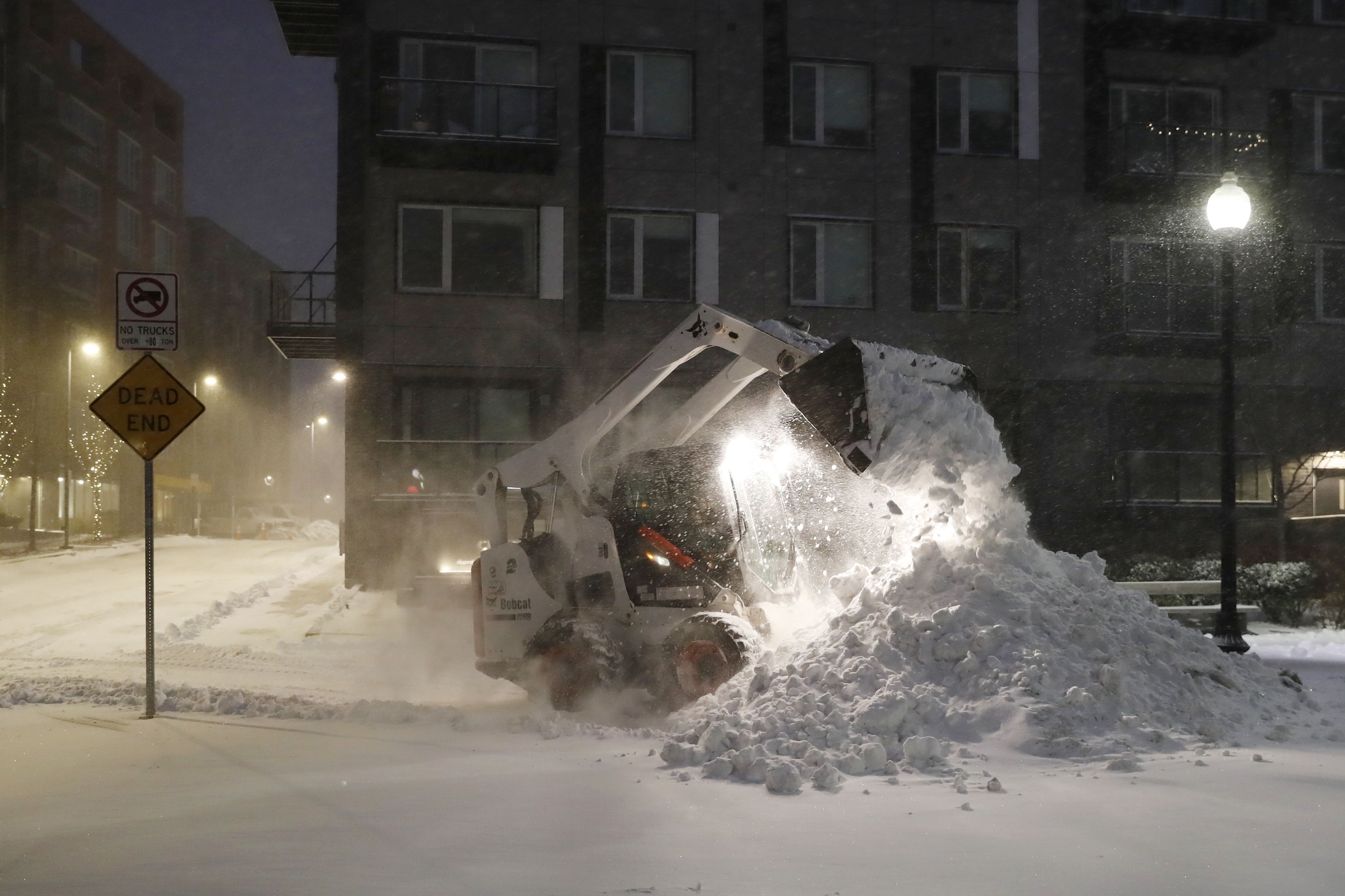 A frontend loader removes snow at Clipper Ship Wharf in the East Boston neighborhood of Boston.