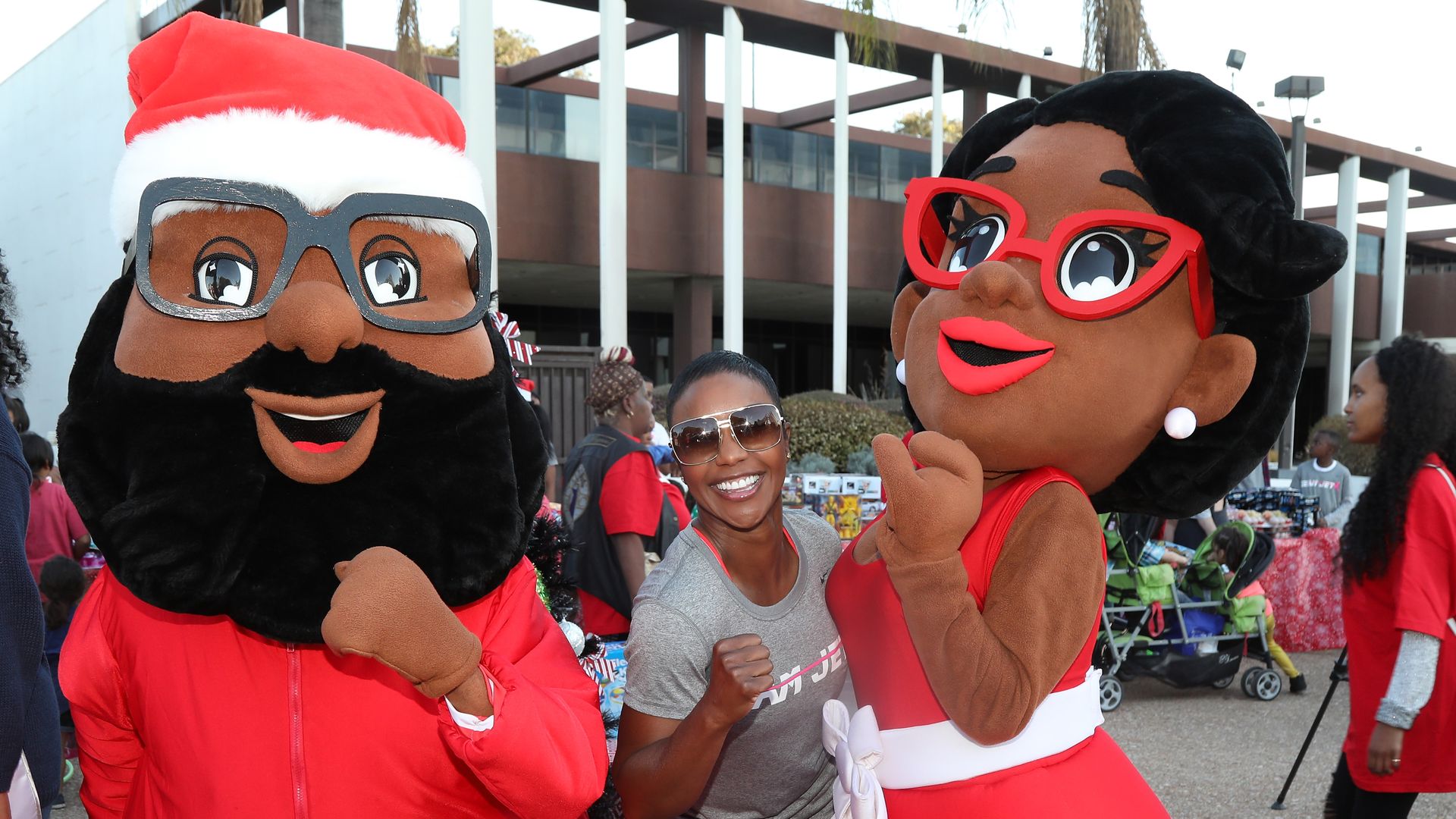 American Sprinter Carmelita Jeter gives a Black power fist with Mr. and Mrs. Black Santa at an annual Compton, Califorina, Toy Giveaway