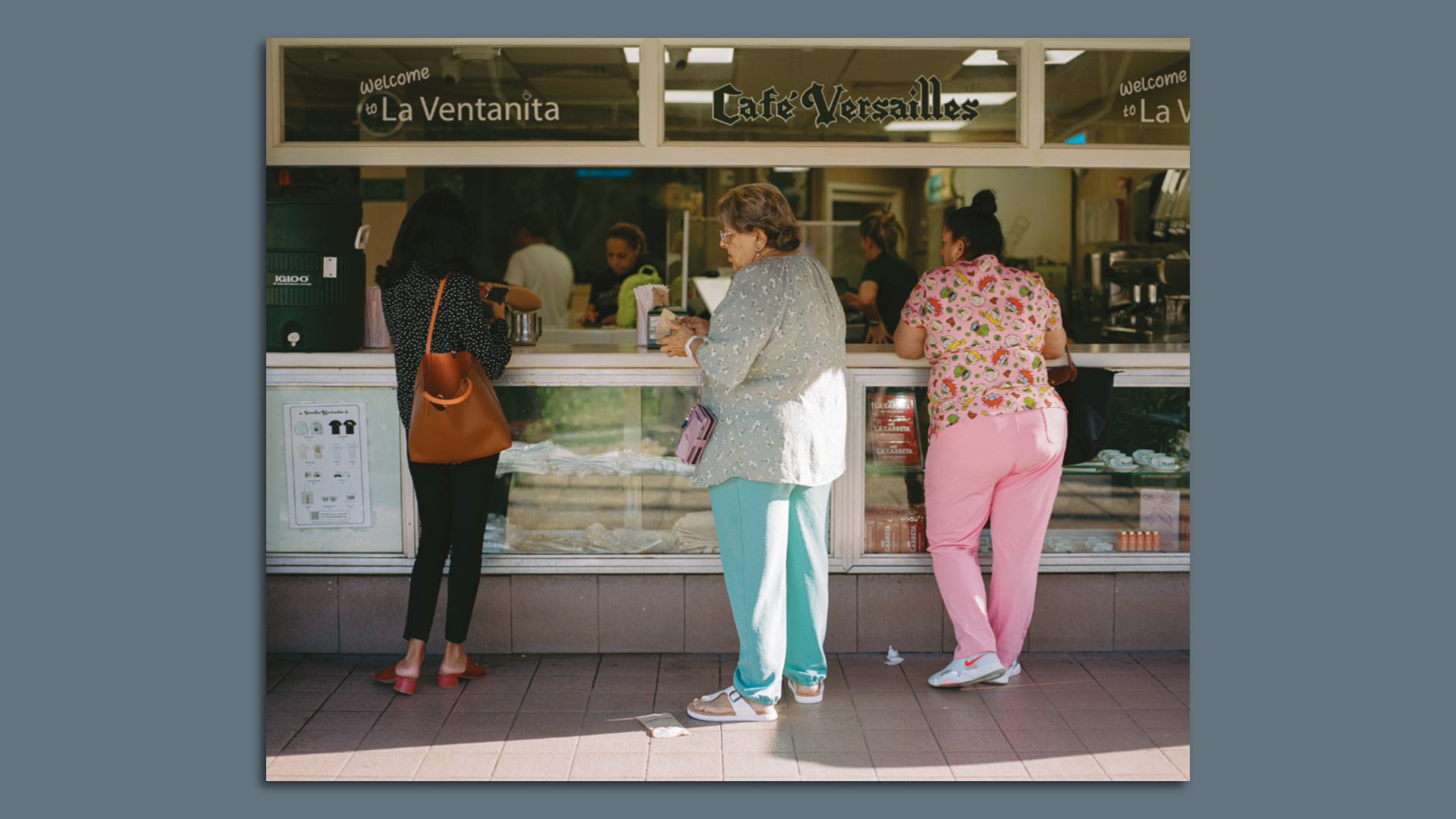Three women stand at the ventanita at Versailles.