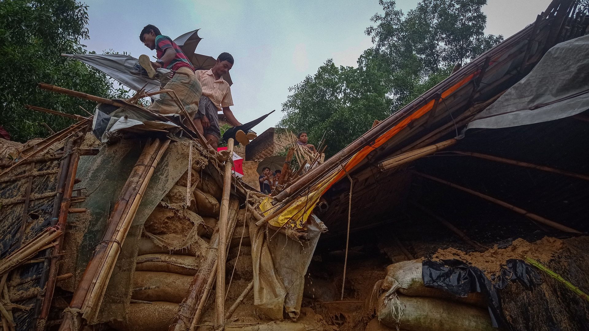 Rohingya refugees work amid the debris of a house in Balukhali camp on July 27, 2021.