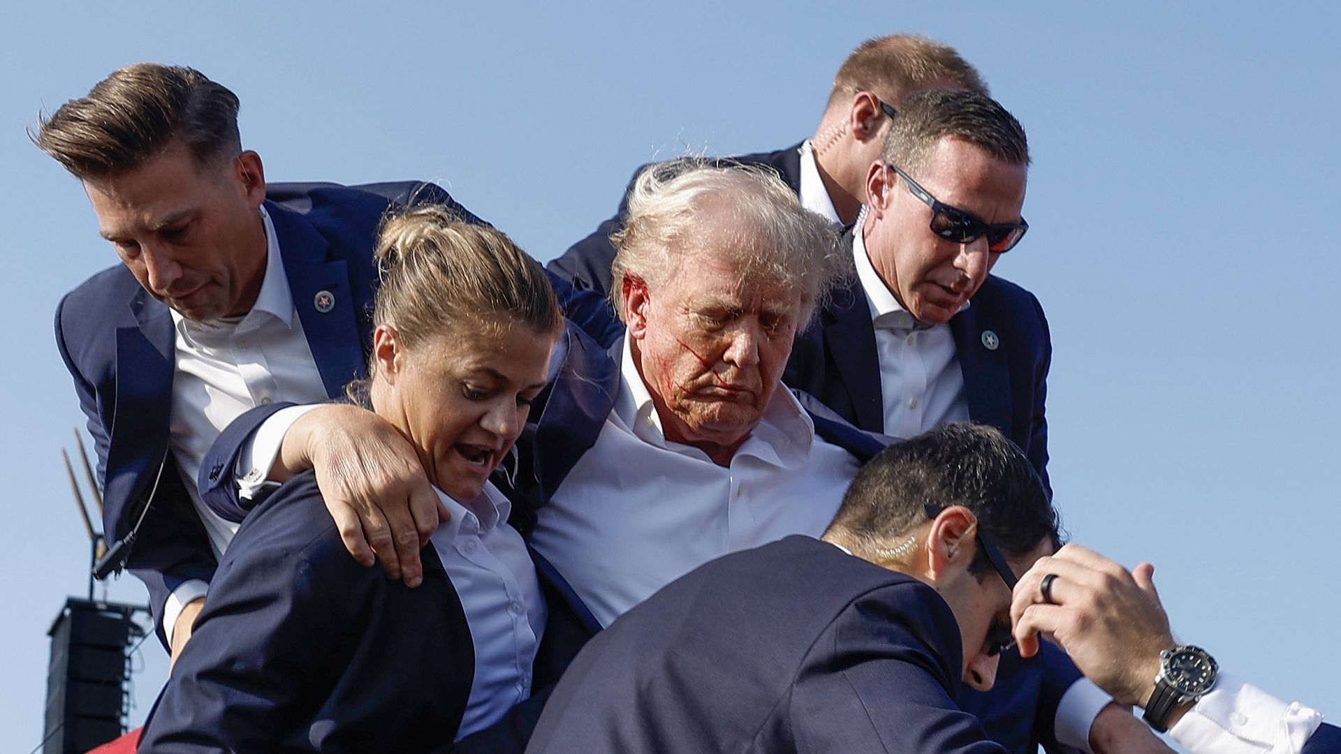 Republican presidential candidate former President Donald Trump is rushed offstage by U.S. Secret Service agents after being grazed by a bullet during a rally on July 13, 2024 in Butler, Pennsylvania. 