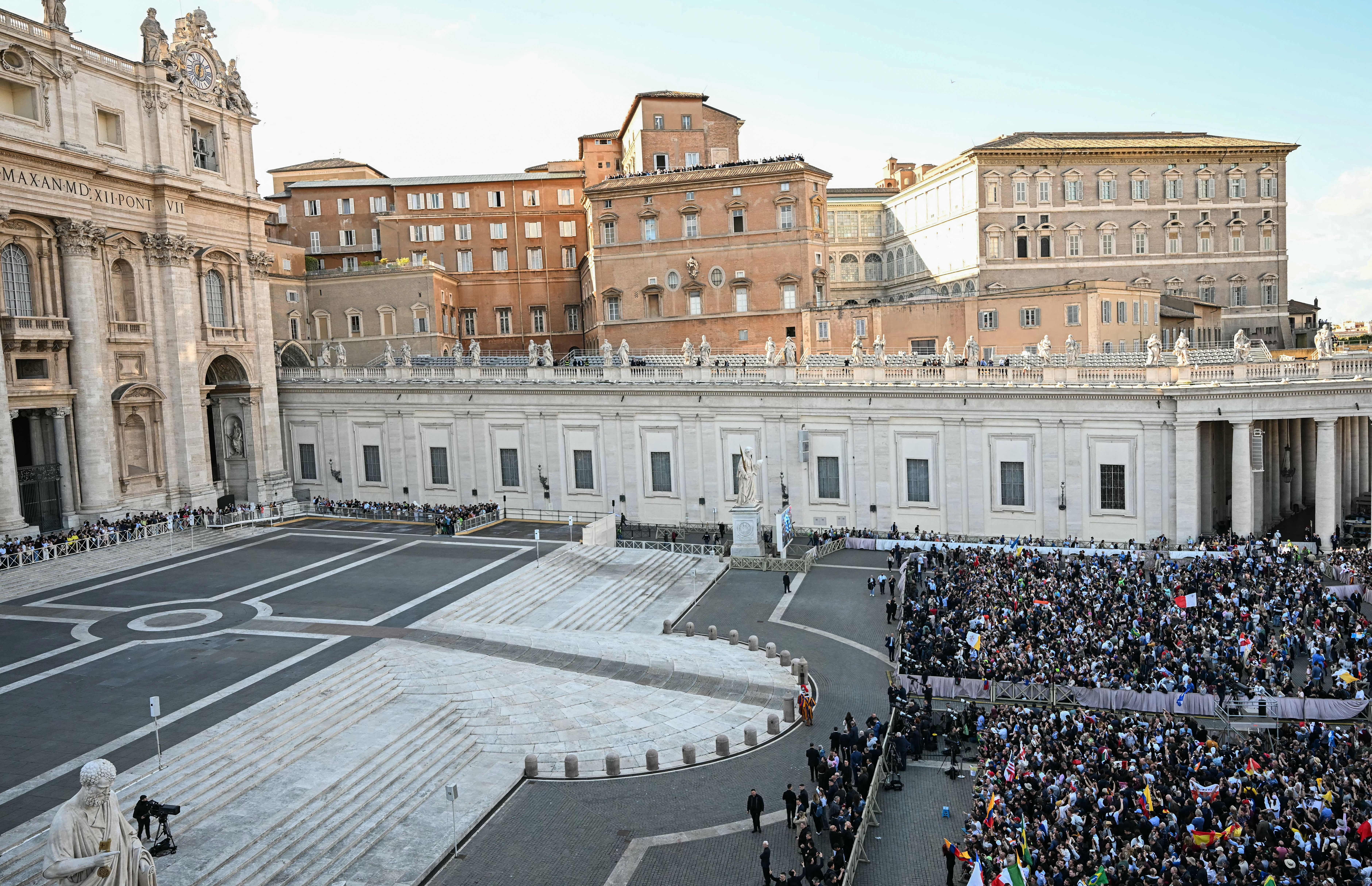 People react at St Peter's Square next to the St Peter's Basilica (L) as the cardinals signaled they elected a new pope during their secret conclave, in The Vatican, on May 8, 2025. 