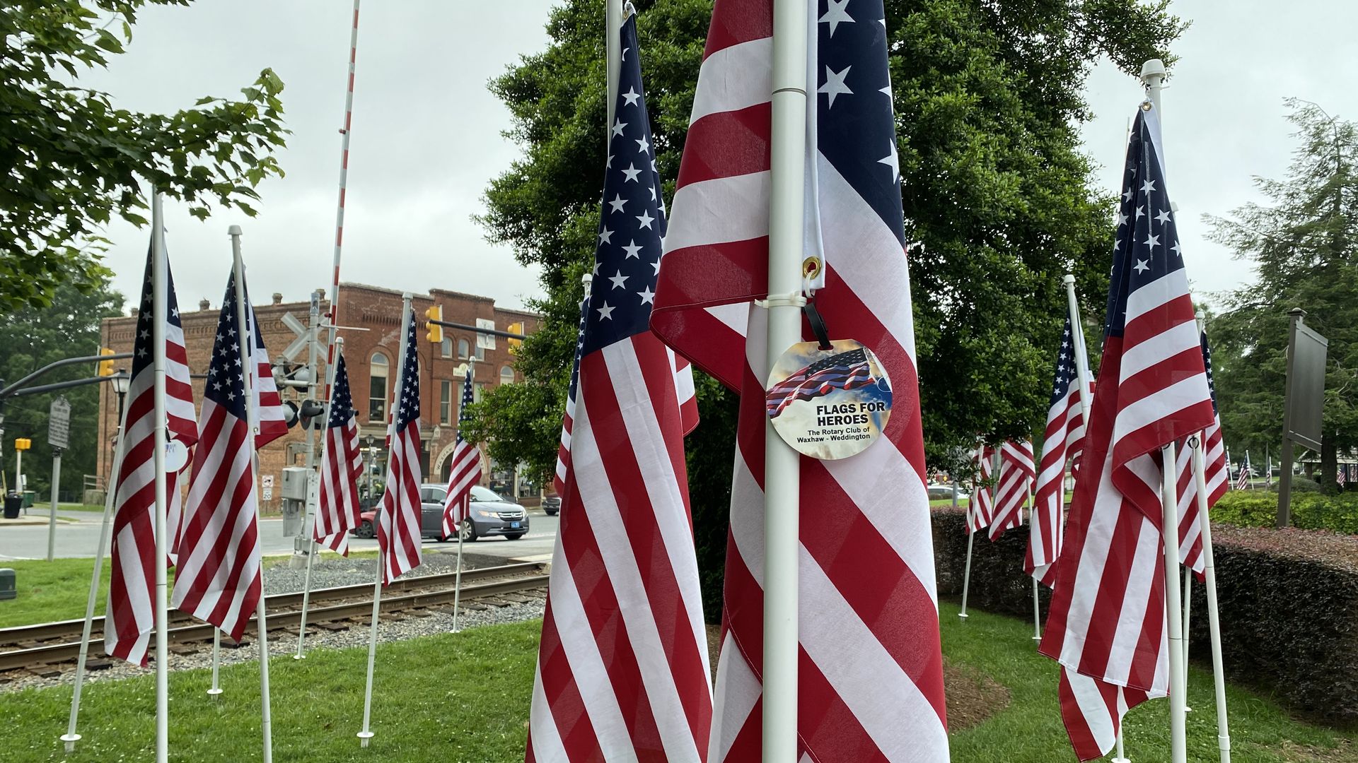 Rows of American flags beside railroad tracks in downtown Waxhaw