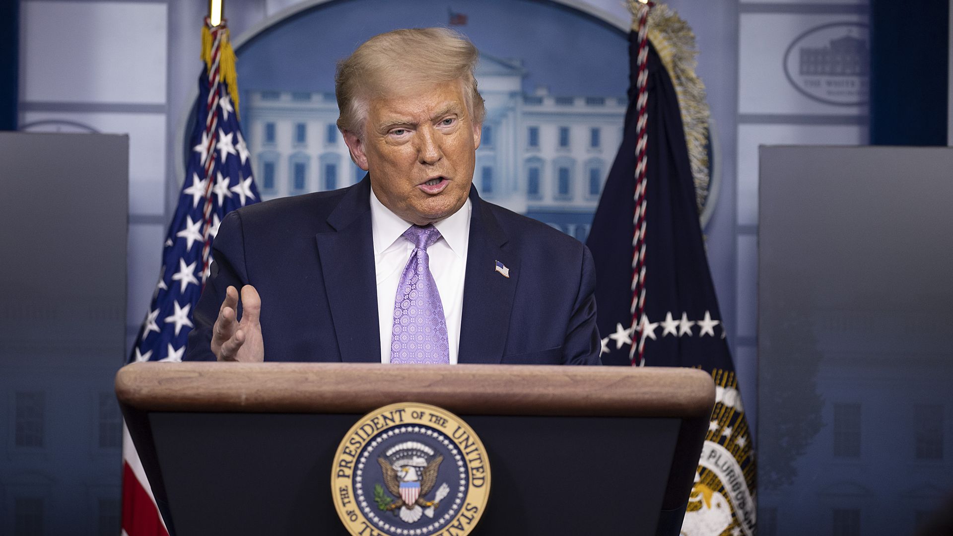 President Trump speaks at a podium in the White House press room