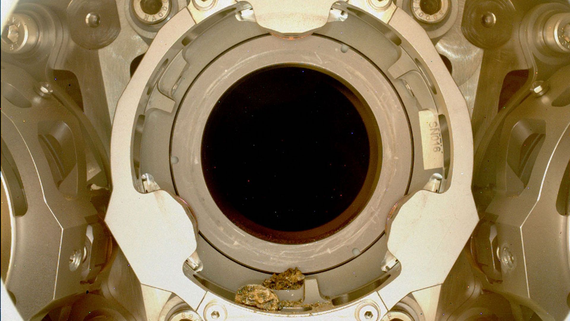 Bits of rock on the lip of the Perseverance rover's sample collection system