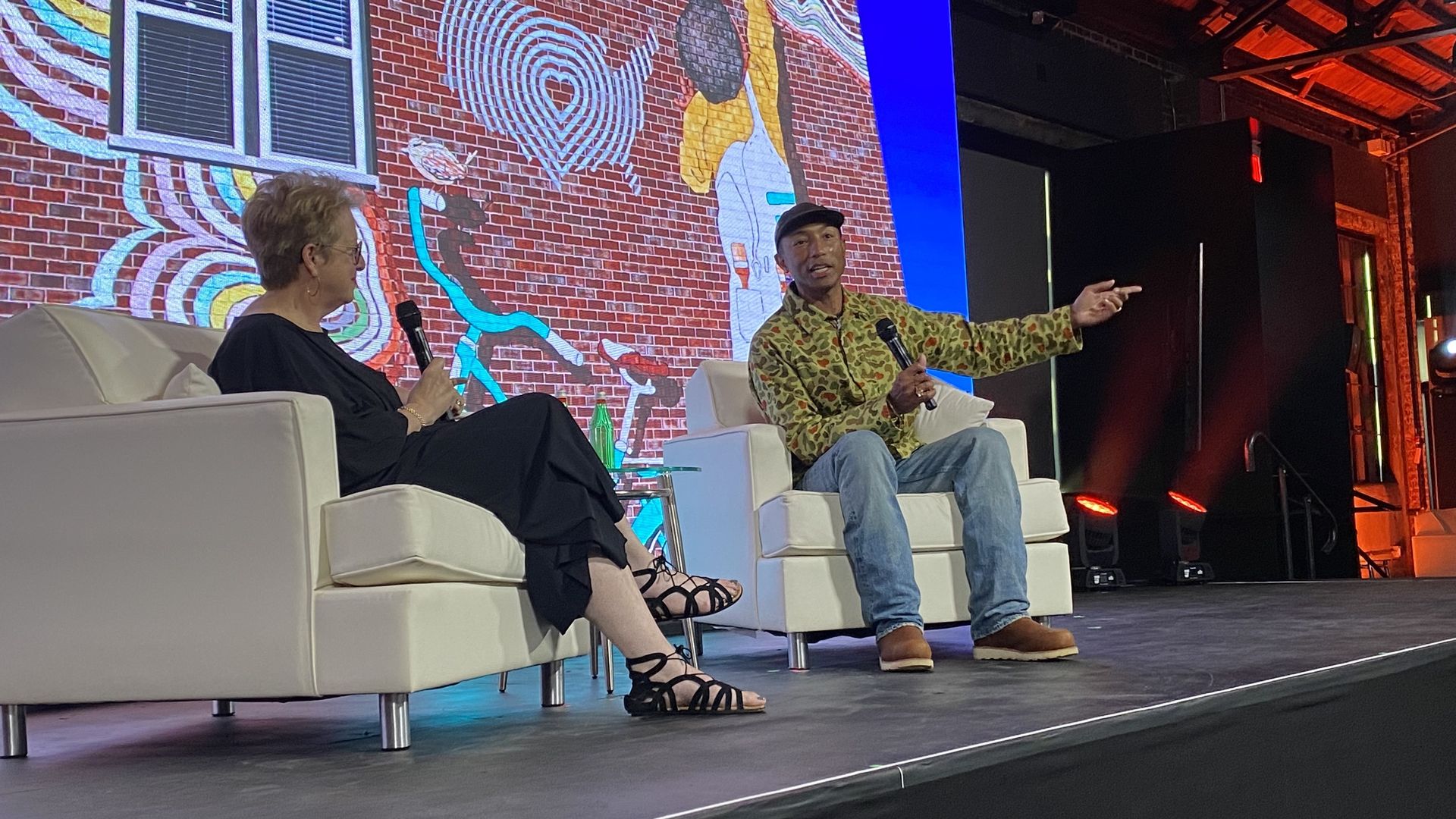 Walton Family Foundation executive director Caryl Stern talks with Pharell Williams. Photo: Worth Sparkman/Axios 