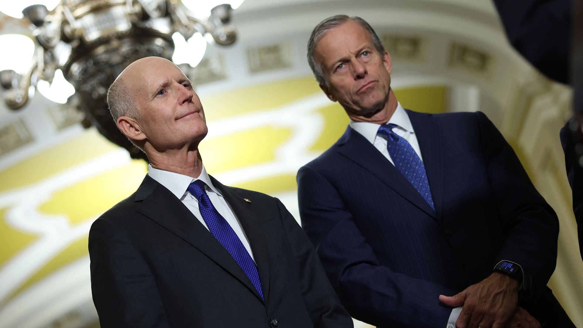 Sen. Rick Scott (R-FL (L) and Sen. John Thune (R-SD) wait to speak to reporters following the Senate weekly policy luncheons