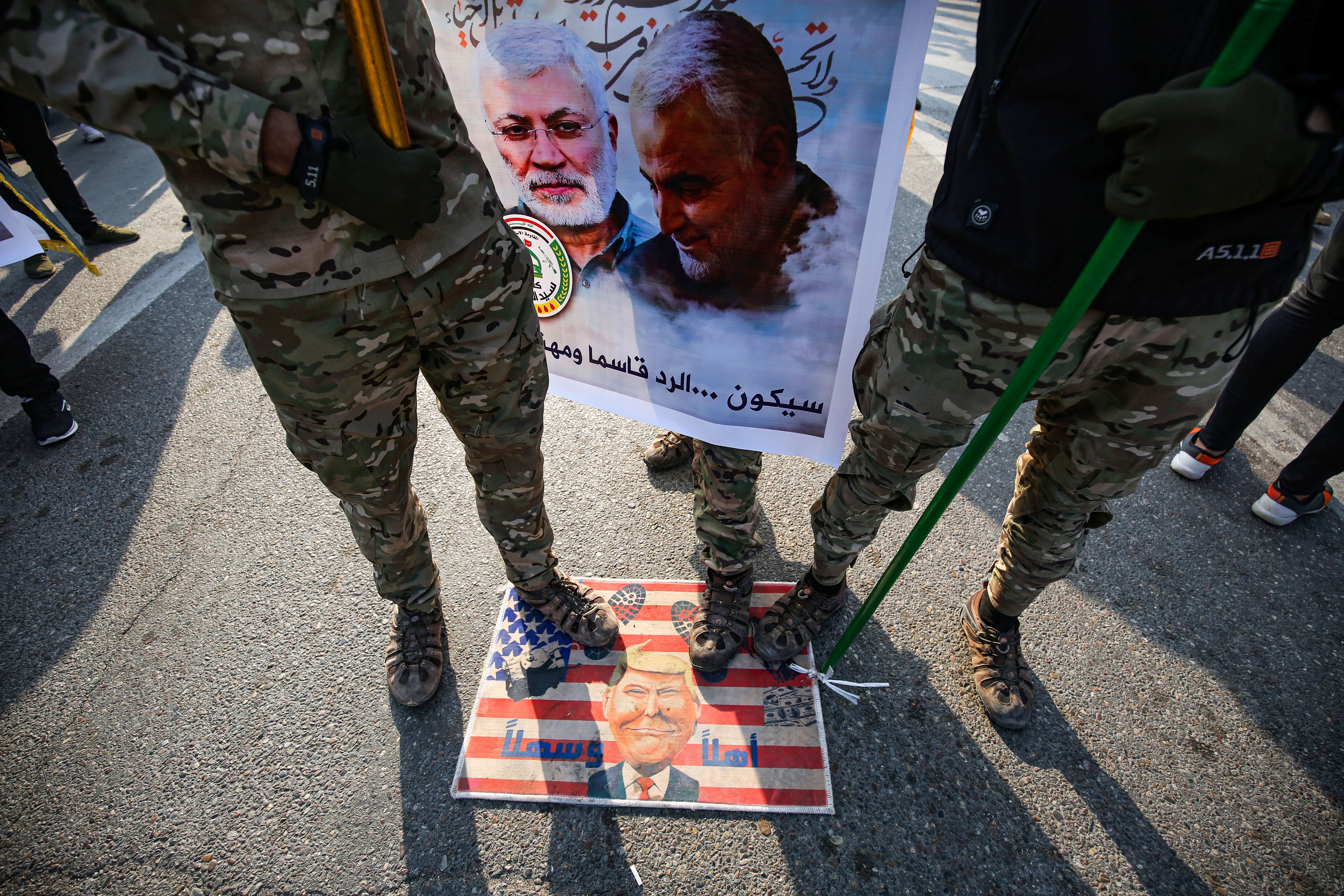 Members of the Hashed al-Shaabi paramilitary force step on a makeshift US flag 