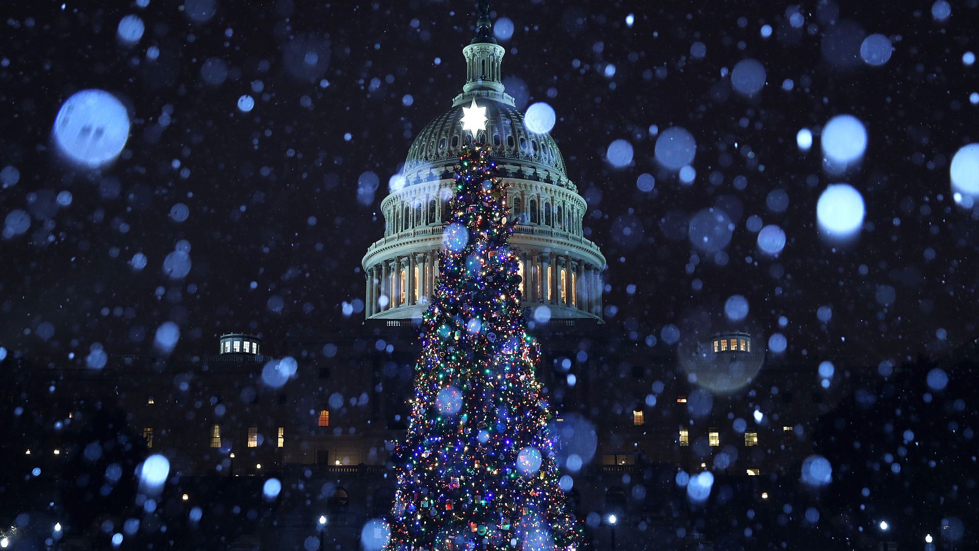A wintry mix of sleet and snow falls on the U.S. Capitol and its Christmas Tree