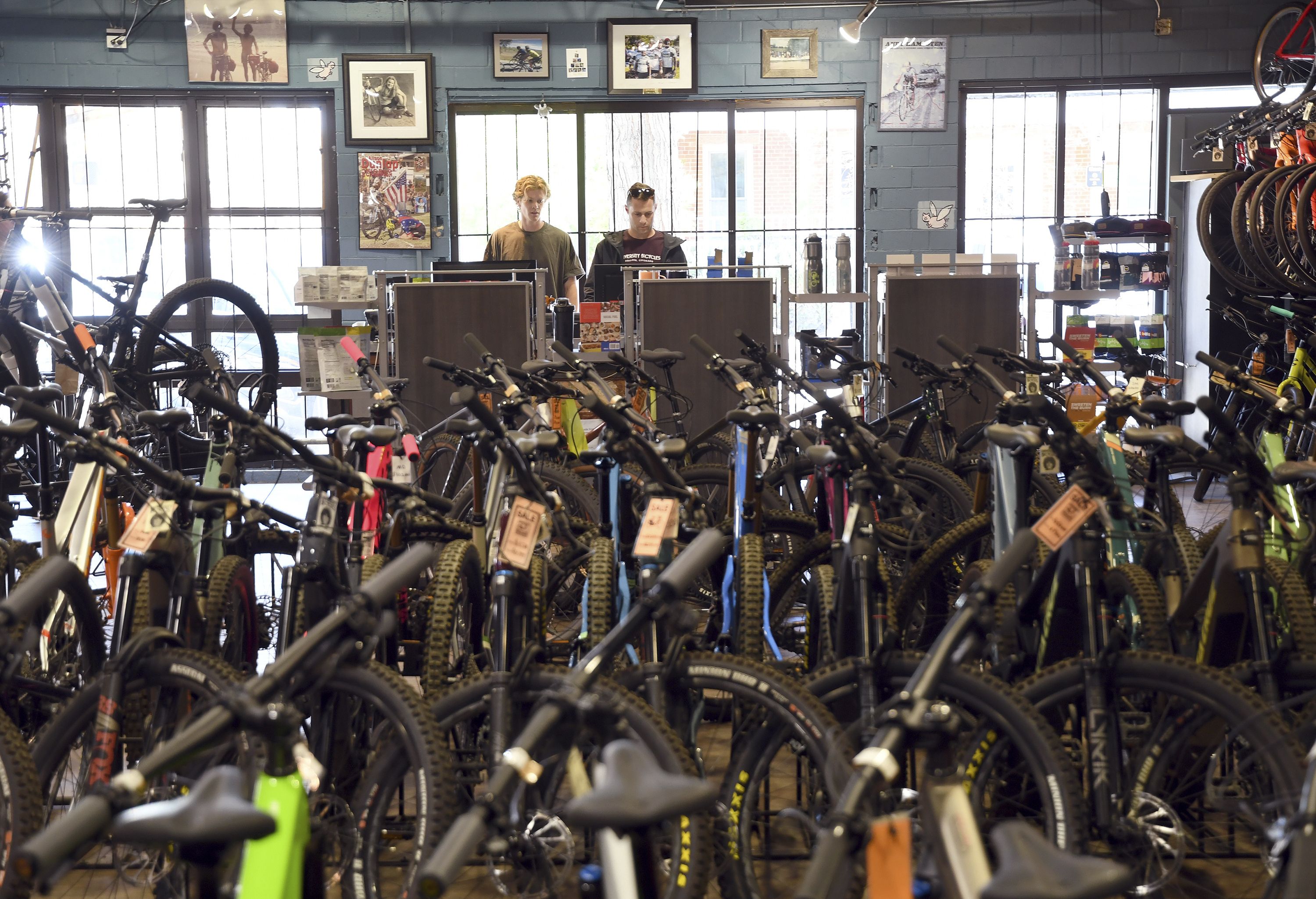 Two men standing in front of many rows of bikes