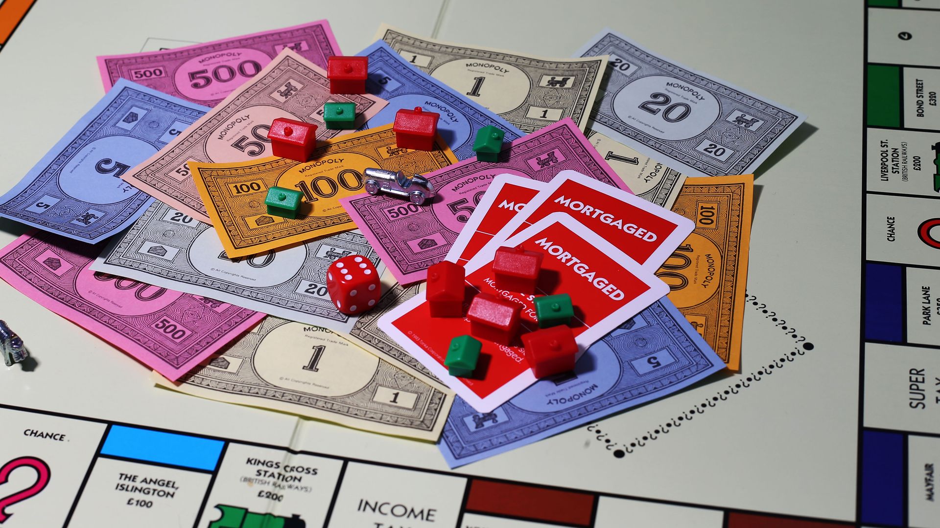 Photo of a Monopoly game board piled with money