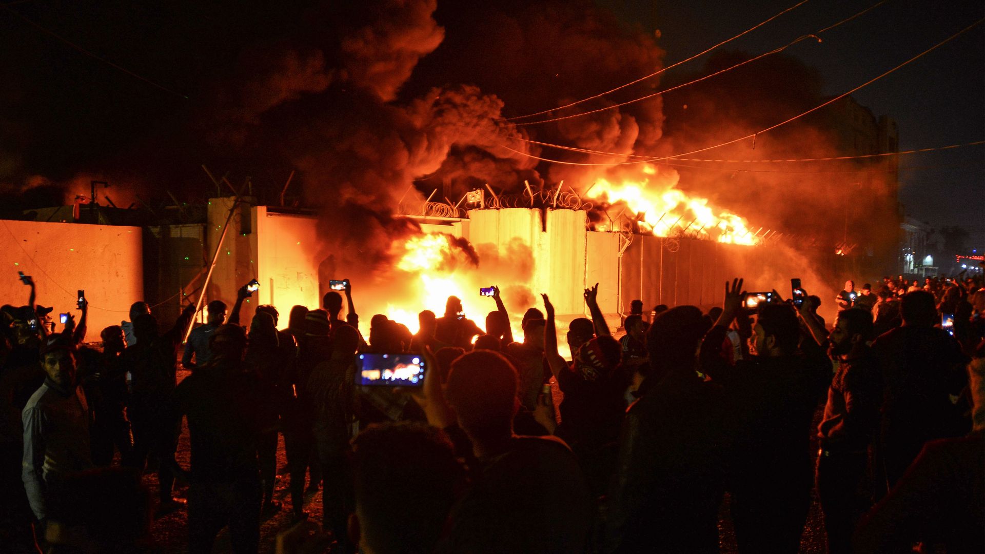 Iraqi demonstrators gather as flames start consuming Iran's consulate in the southern Iraqi Shiite holy city of Najaf