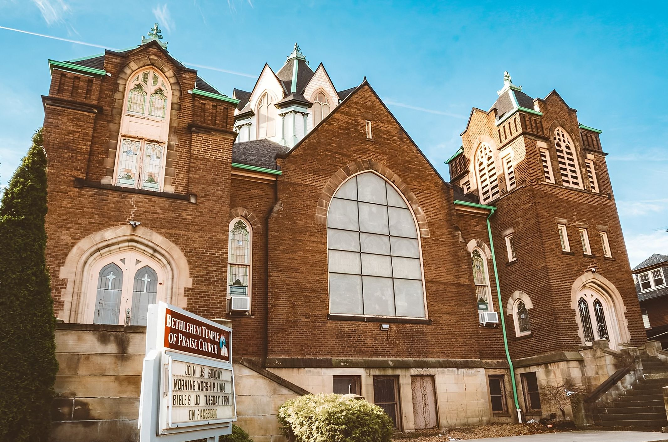 An old church with sign in front. 