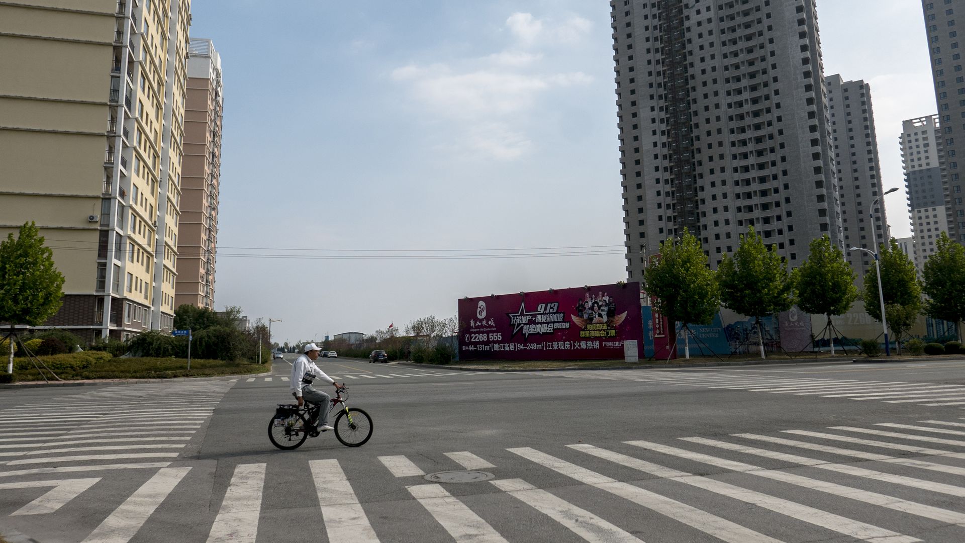 A man rides a bike through an empty city