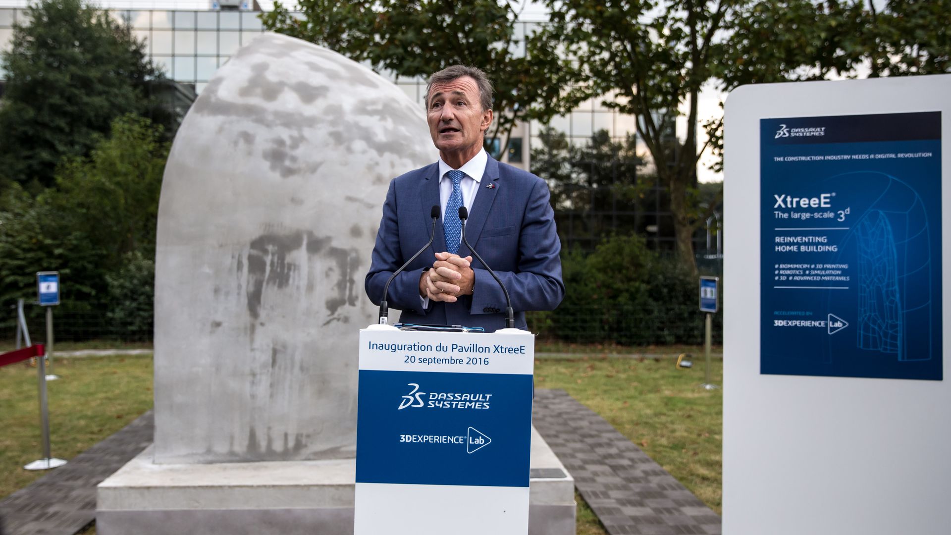 Dassault Systemes CEO Bernard Charles speaks behind a podium.