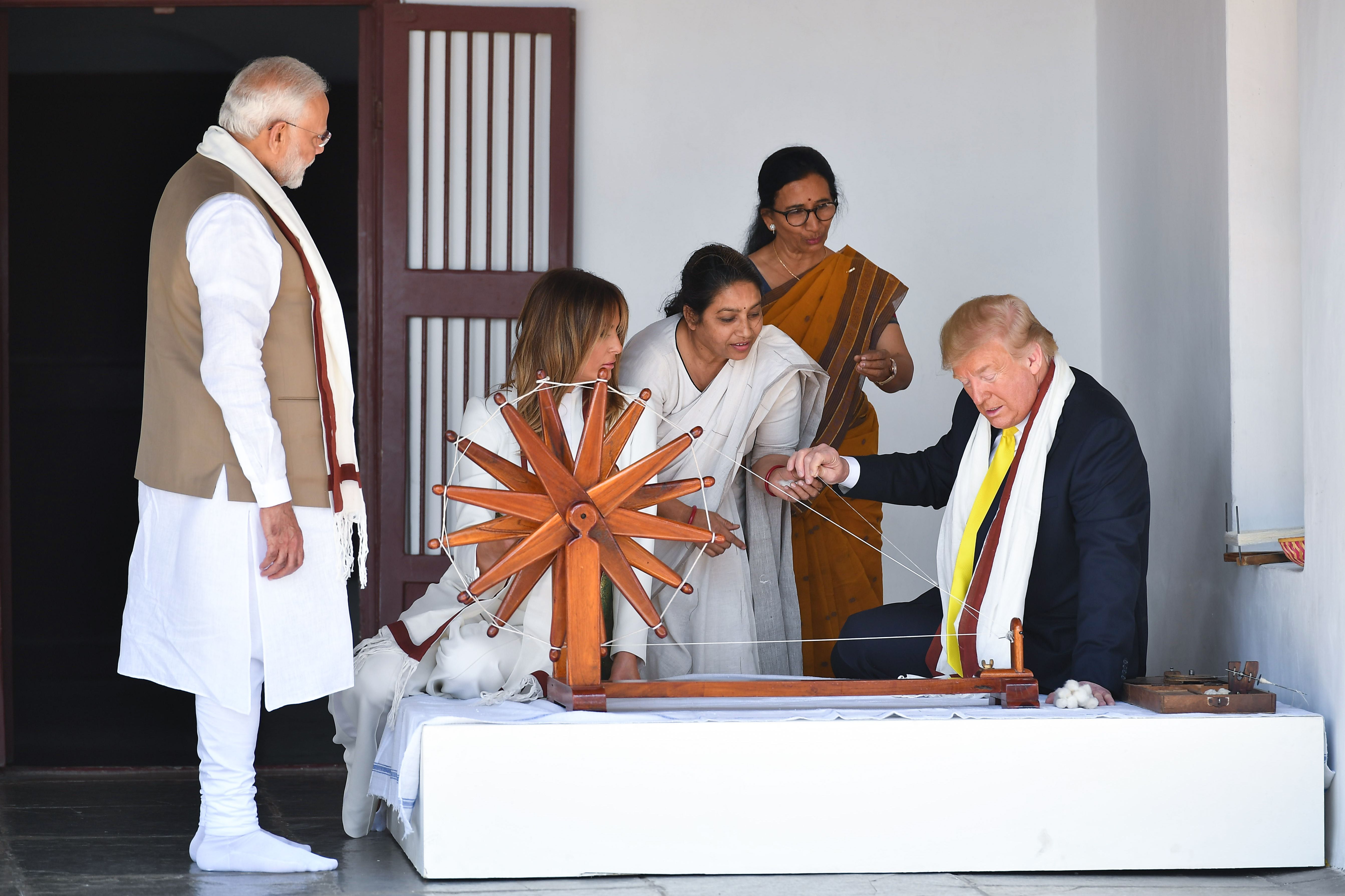  President Donald Trump (R) holds a string while checking a charkha, or spinning wheel,  at the Gandhi Ashram in Ahmedabad on February 24