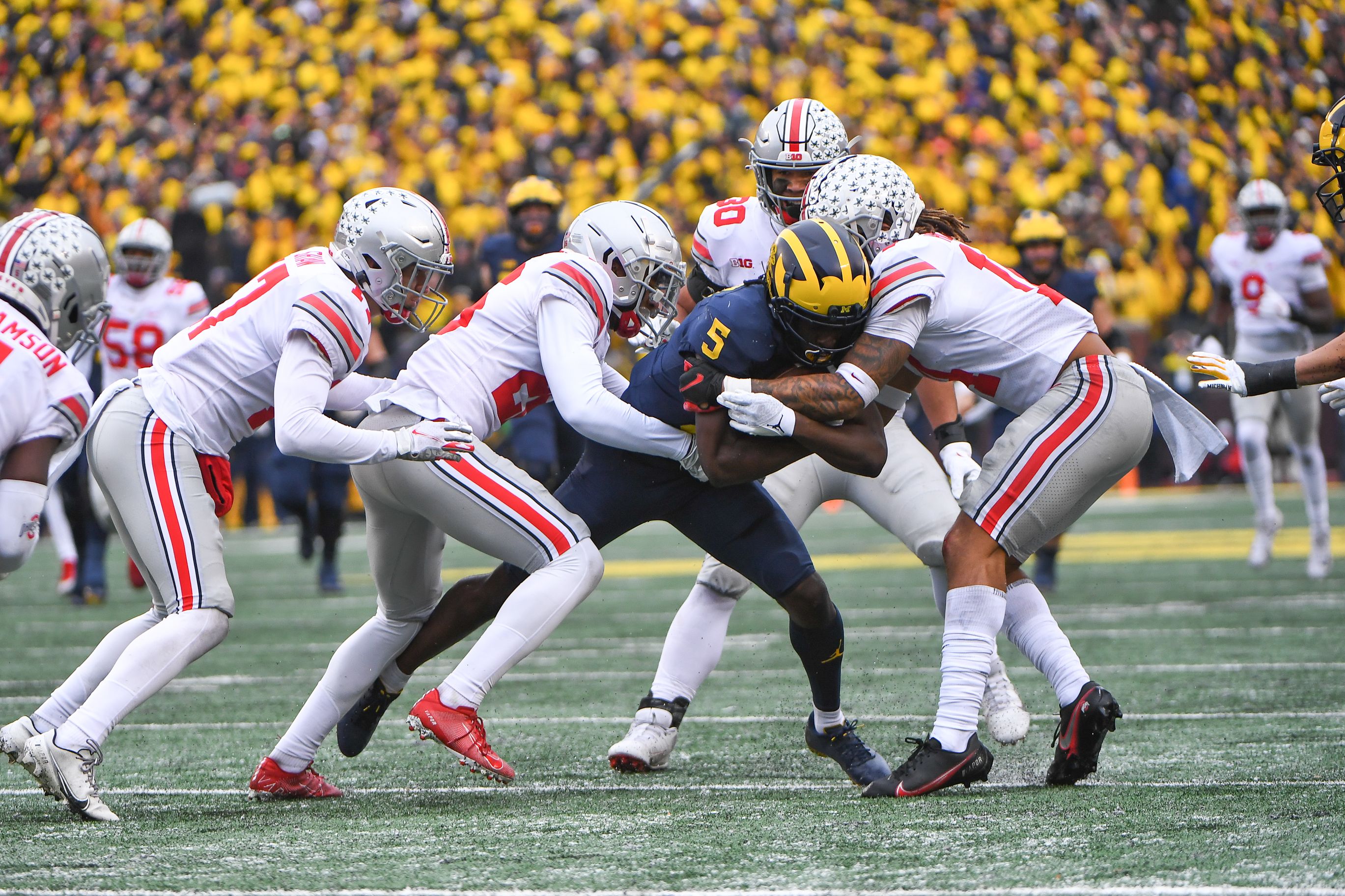 Four Ohio State players combine to tackle a Michigan player with the ball. 