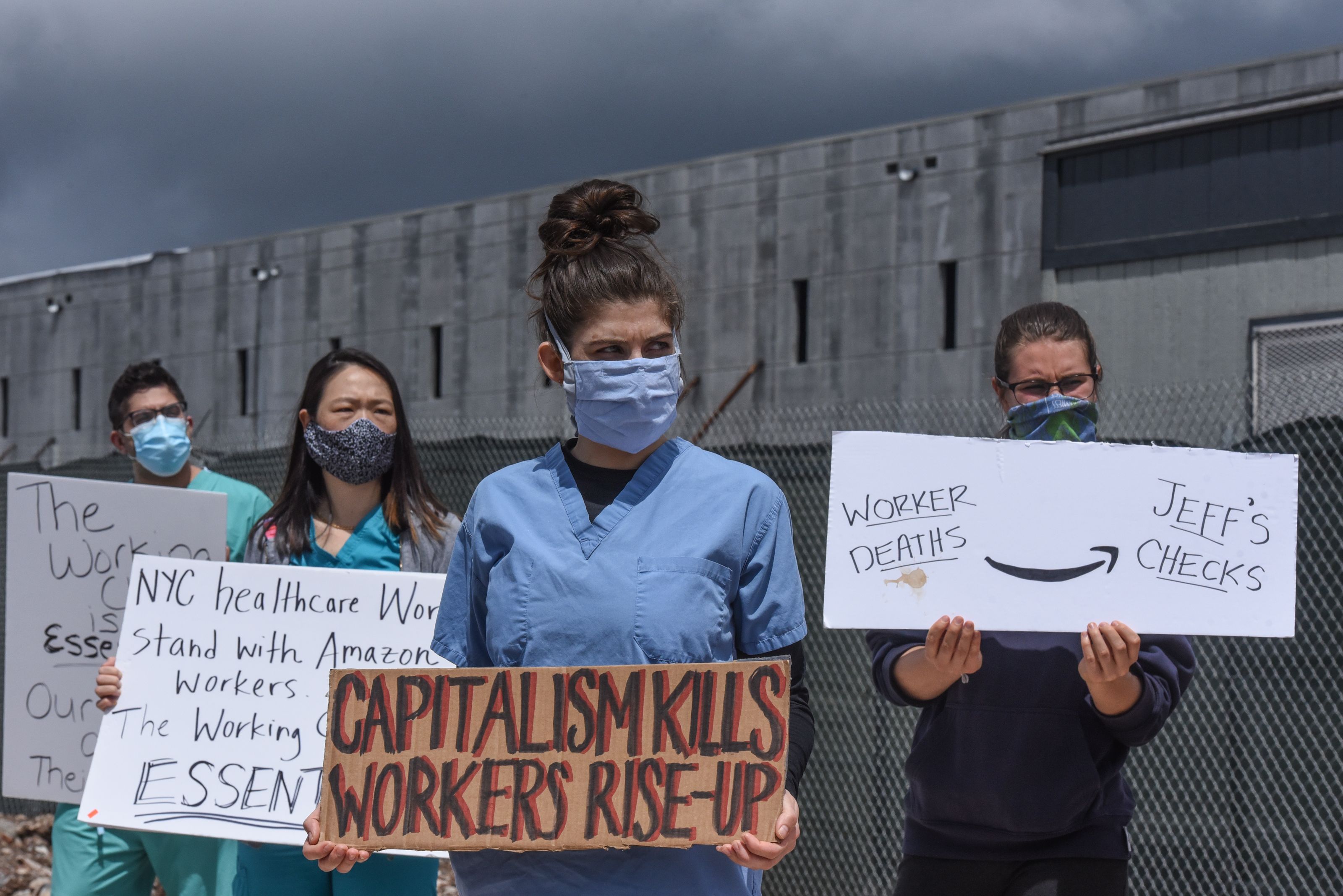 In this photo, several signs read: "Capitalism kills workers rise-up" and "Worker deaths arrow Jeff's checks"