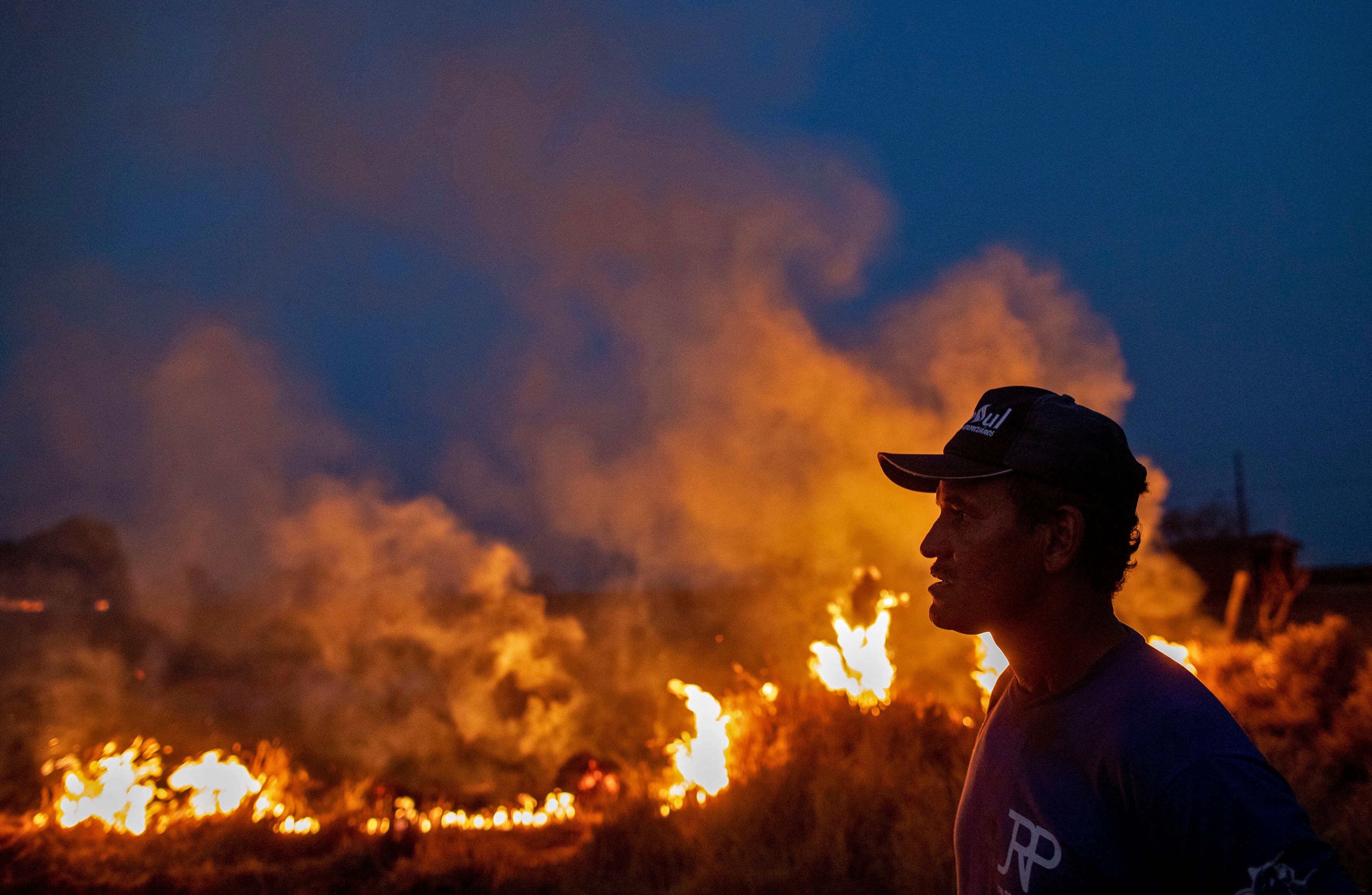 A labourer stares at a fire that spread to the farm he work on next to a highway in Nova Santa Helena municipality in northern Mato Grosso State, south in the Amazon basin in Brazil