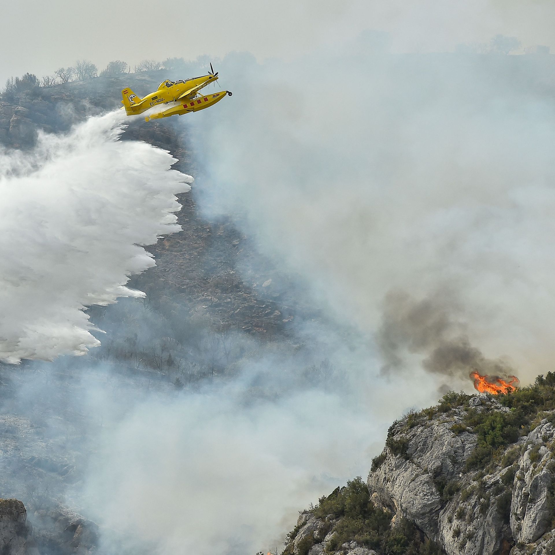 A firefighting plane drops water on a blaze near Artesa de Segre, in Catalonia, Spain, on June 16.