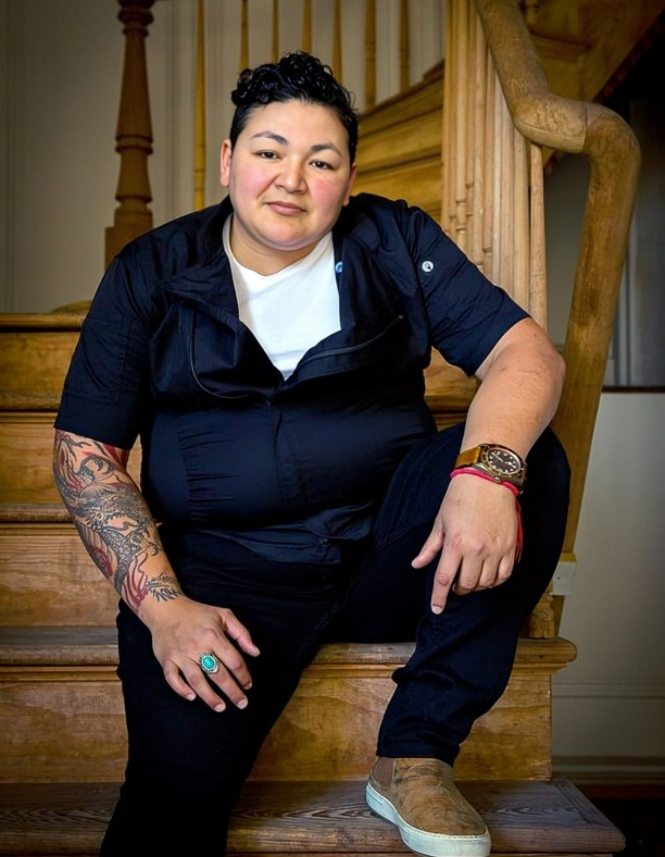 A person poses for a photo on the stairs.