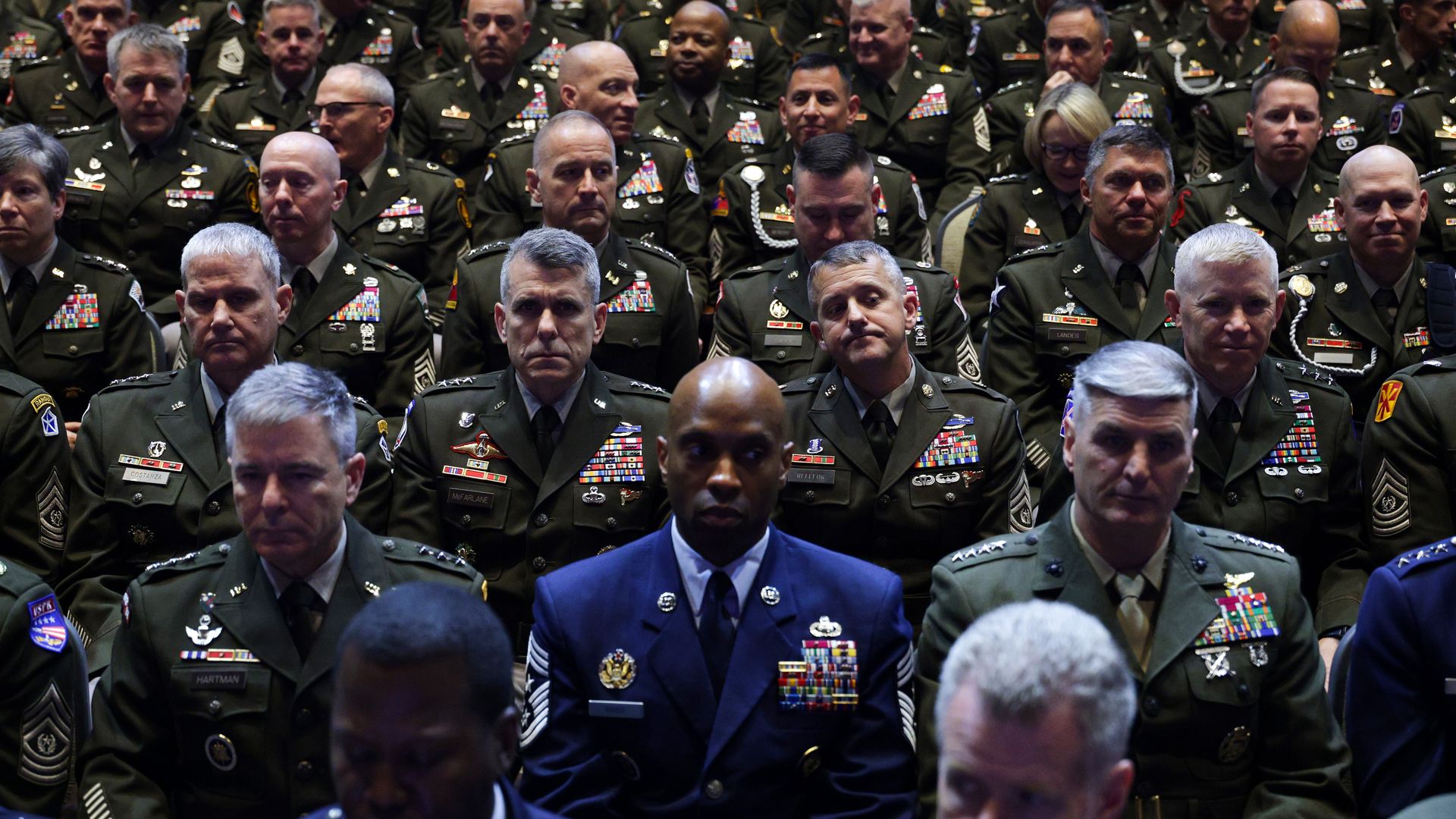 Rows of senior military officials wearing green and blue uniforms look on during an address at Quantico.