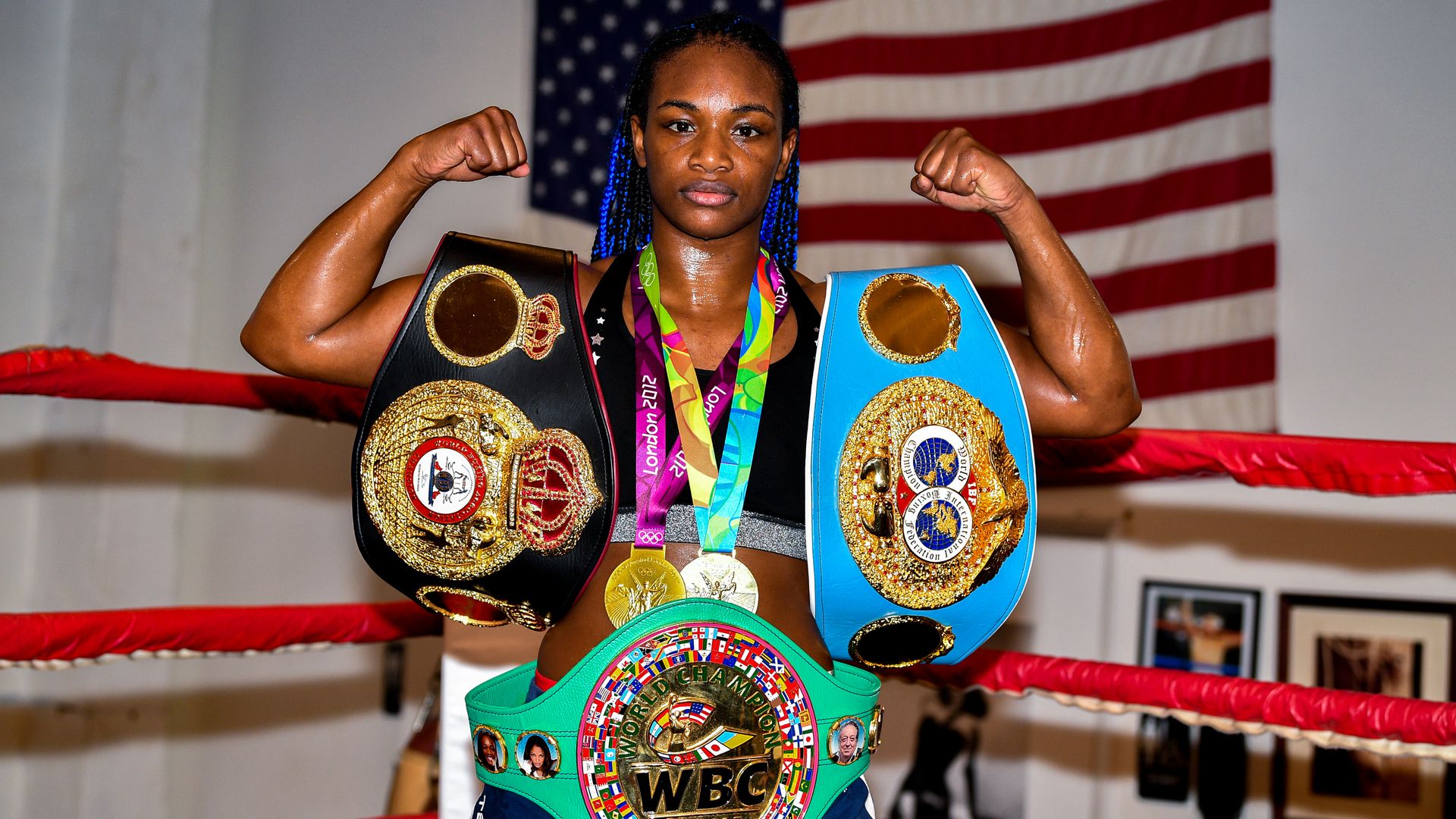 claressa shields posing with belts and medals