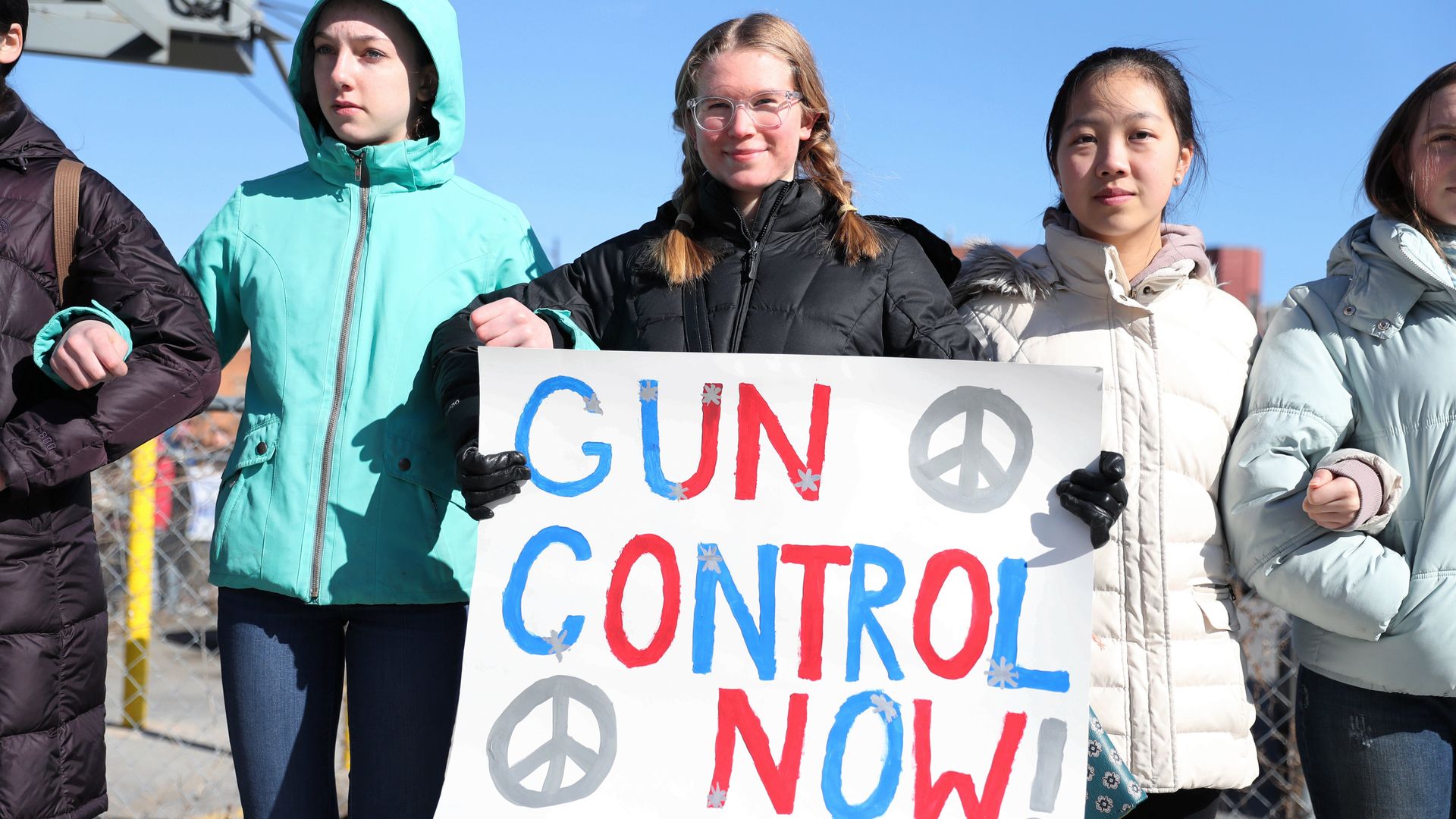 girls hold sign that says "gun control now!"