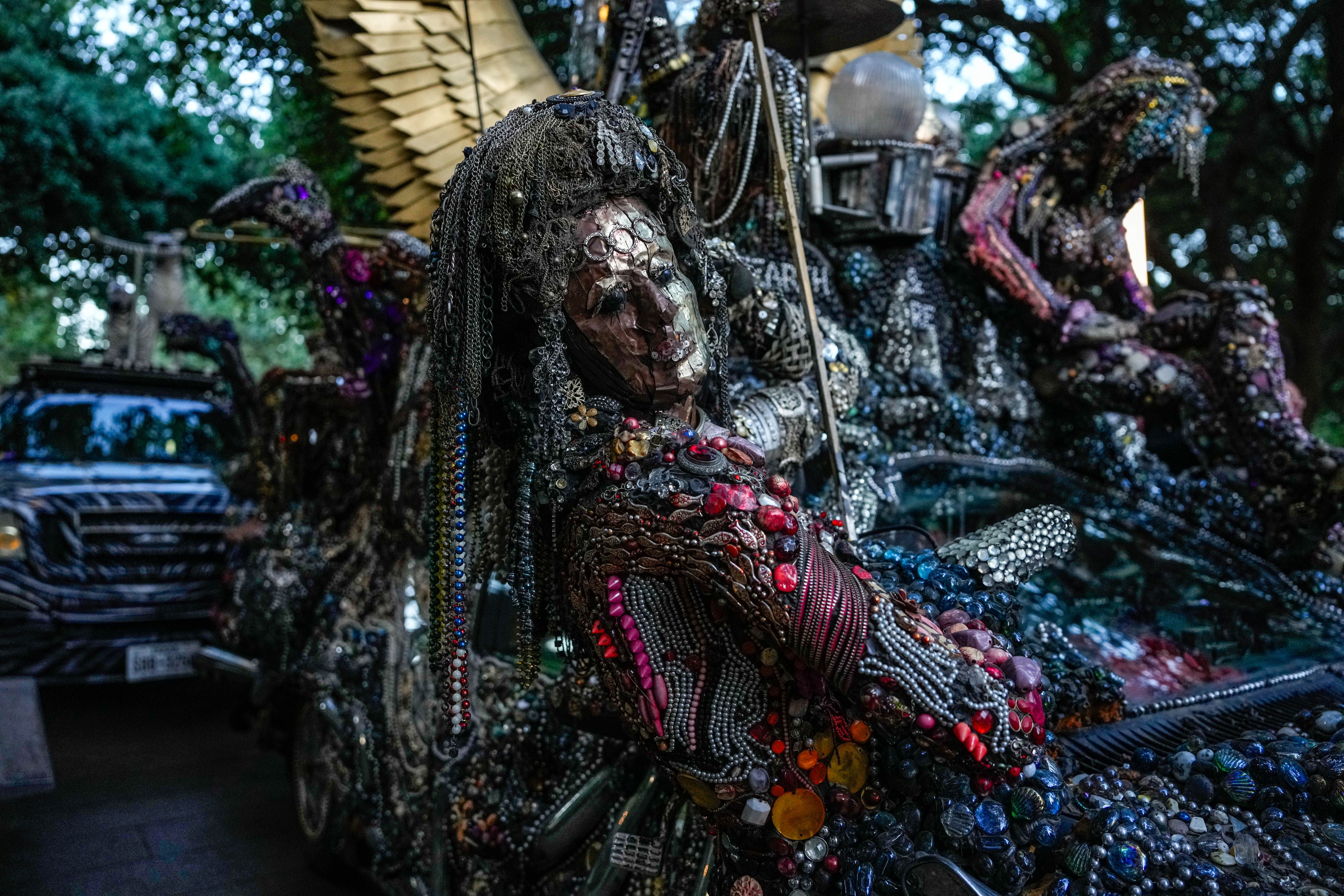 Photo of a person dressed up to match their art car. 