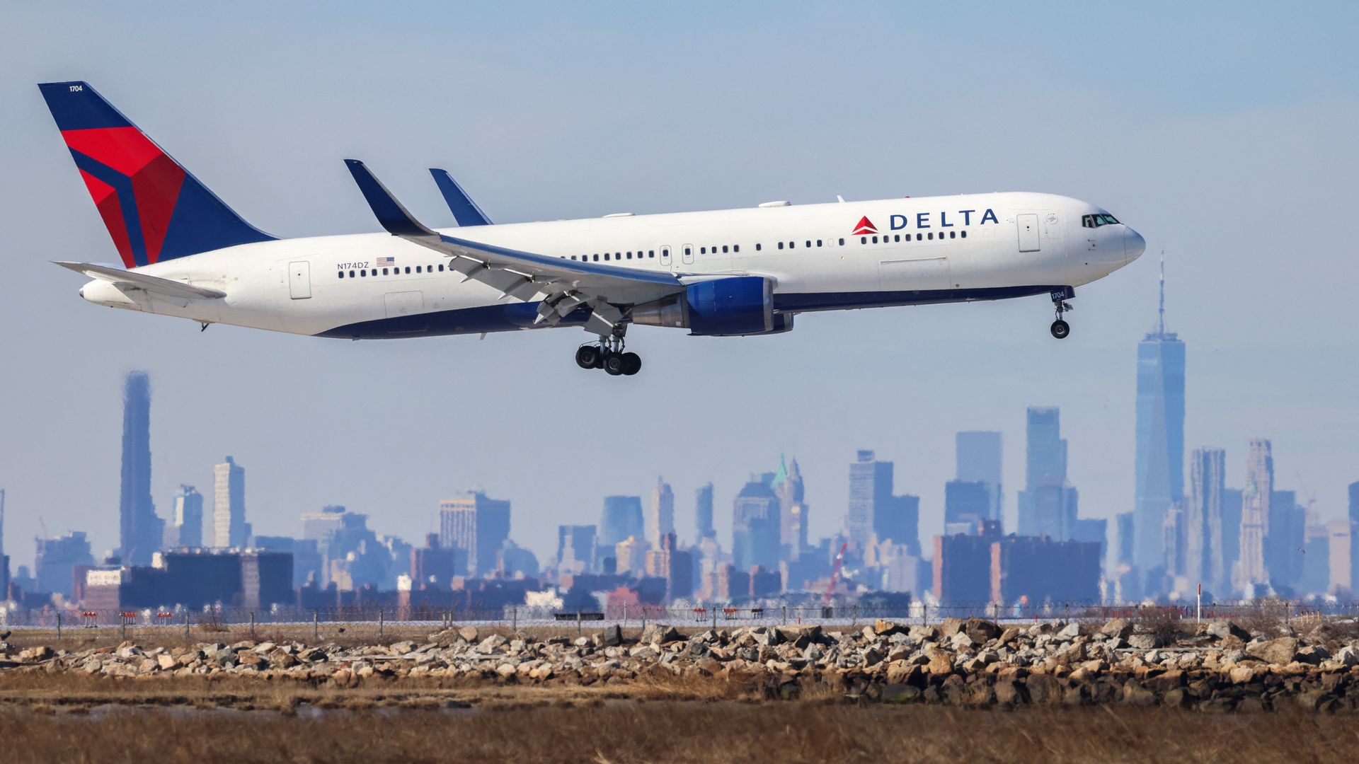 A Delta jet takes off with the New York skyline in the background