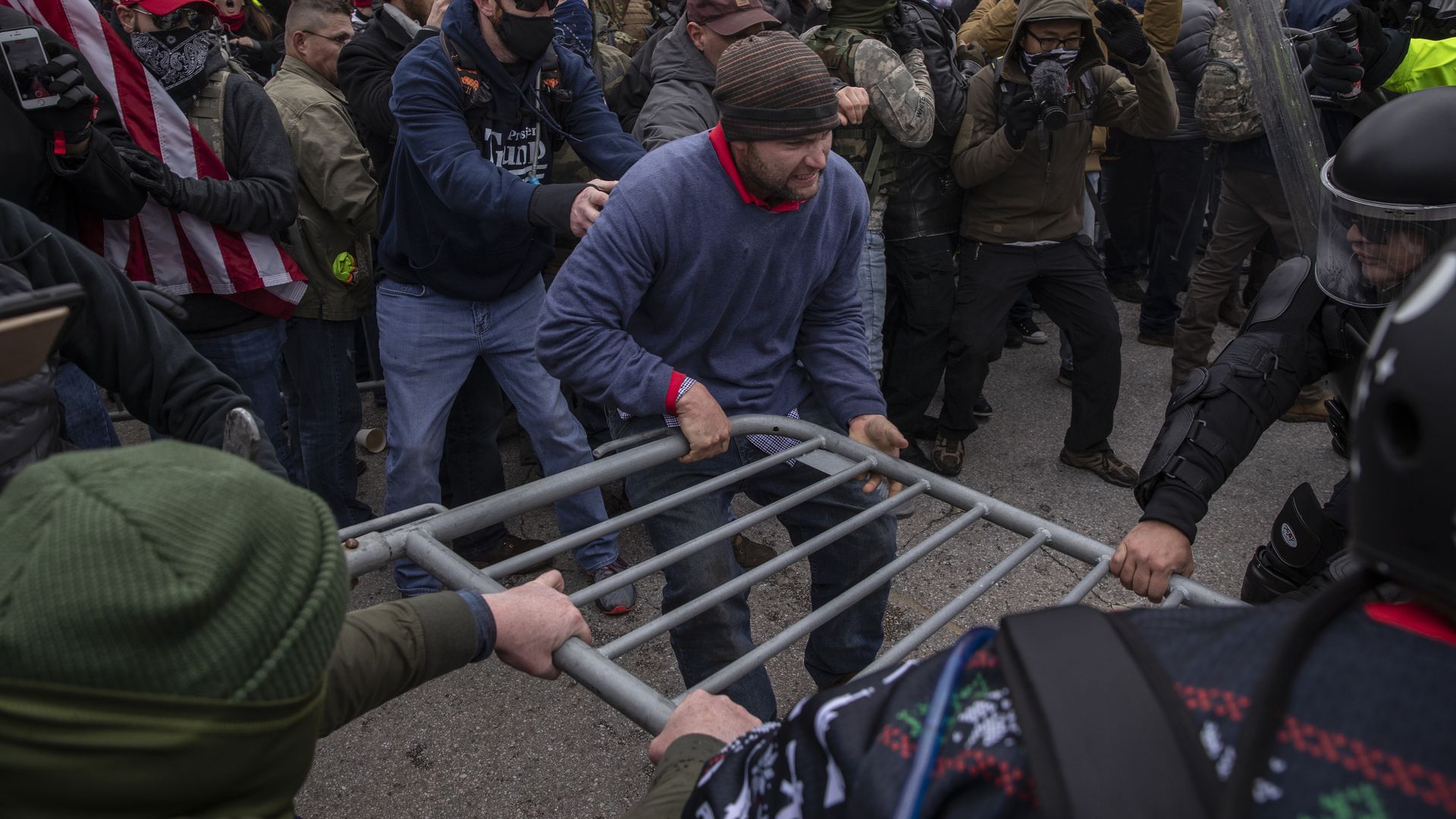 Demonstrators and U.S. Capitol police battle fight over a barricade as the Capitol building grounds are breached in Washington, DC, U.S., on Wednesday, Jan. 6, 2021. 