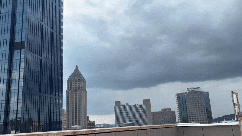 A moving image from a rooftop overlooking a skyline of blue and white buildings in Pittsburgh.