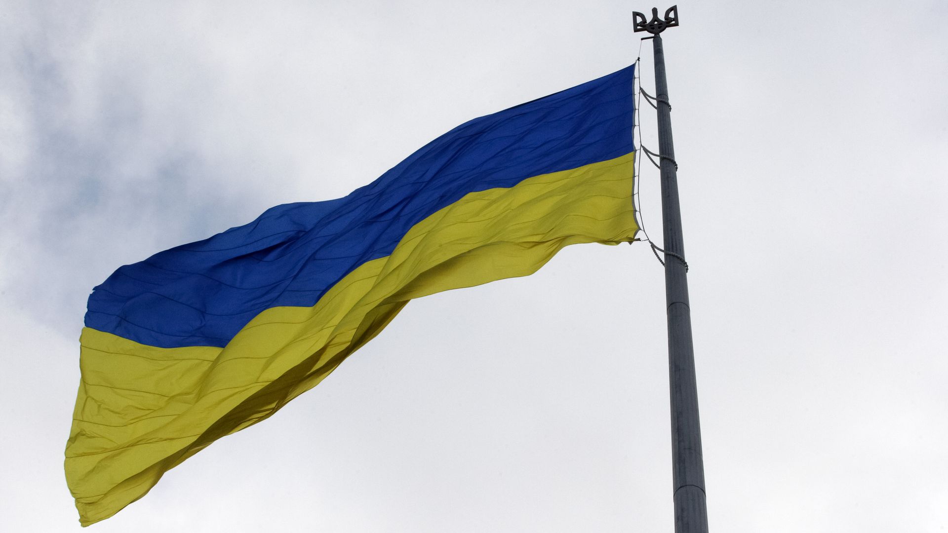 An image of the Ukrainian flag against an overcast sky.
