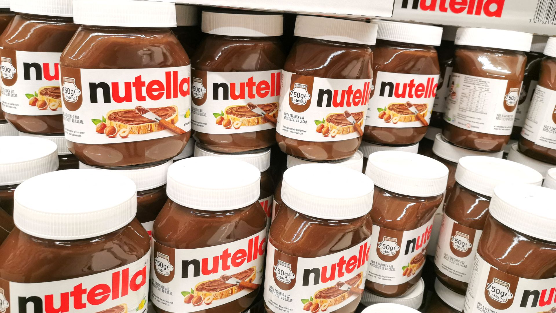 Plastic cans of Nutella are stacked on top of each other