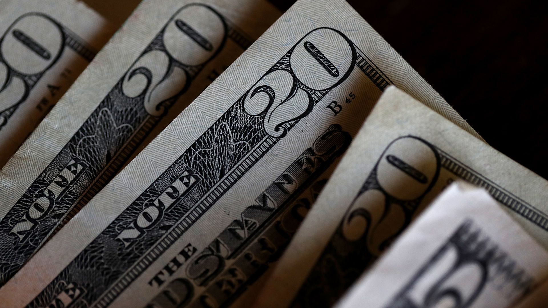 A group of 20 dollar bills and a five dollar bill