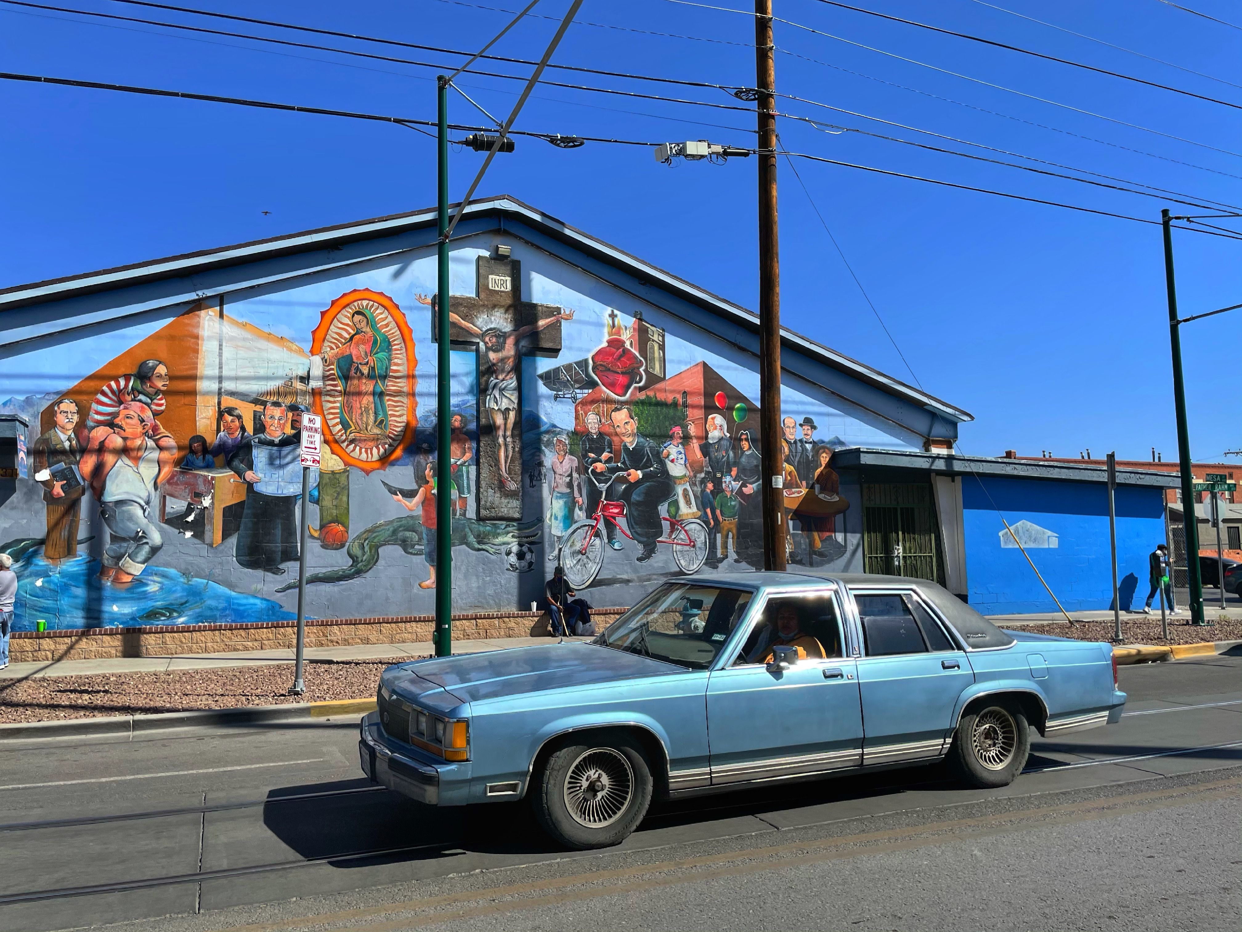 A motorist in a late 1970s car drives by a Chicano mural in El Paso's Segundo Barrio.