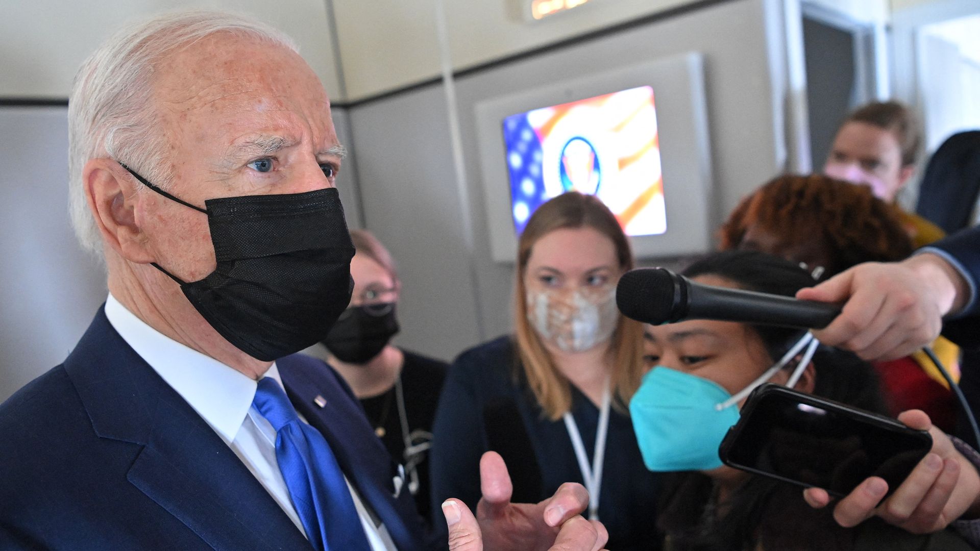 President Biden is seen speaking with reporters in the press cabin aboard Air Force One.