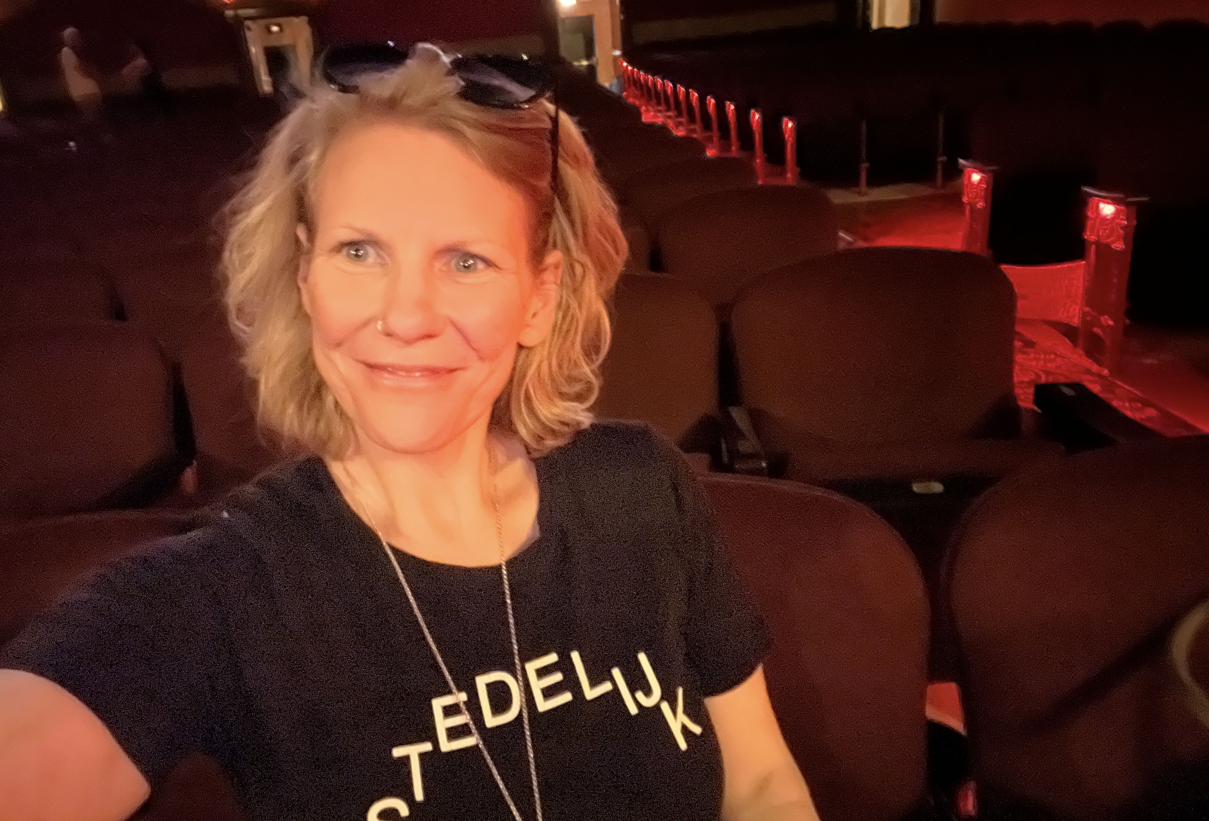 Woman takes a selfie in an empty movie theater.