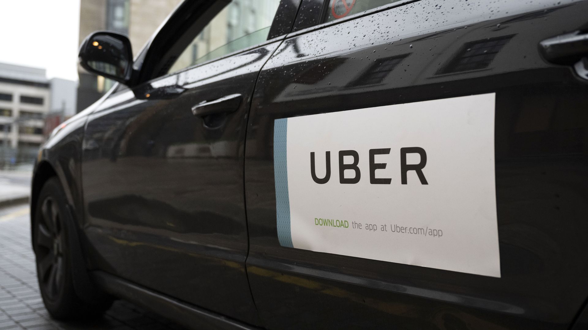 Photo of the left side of the car, which has an Uber sticker on it