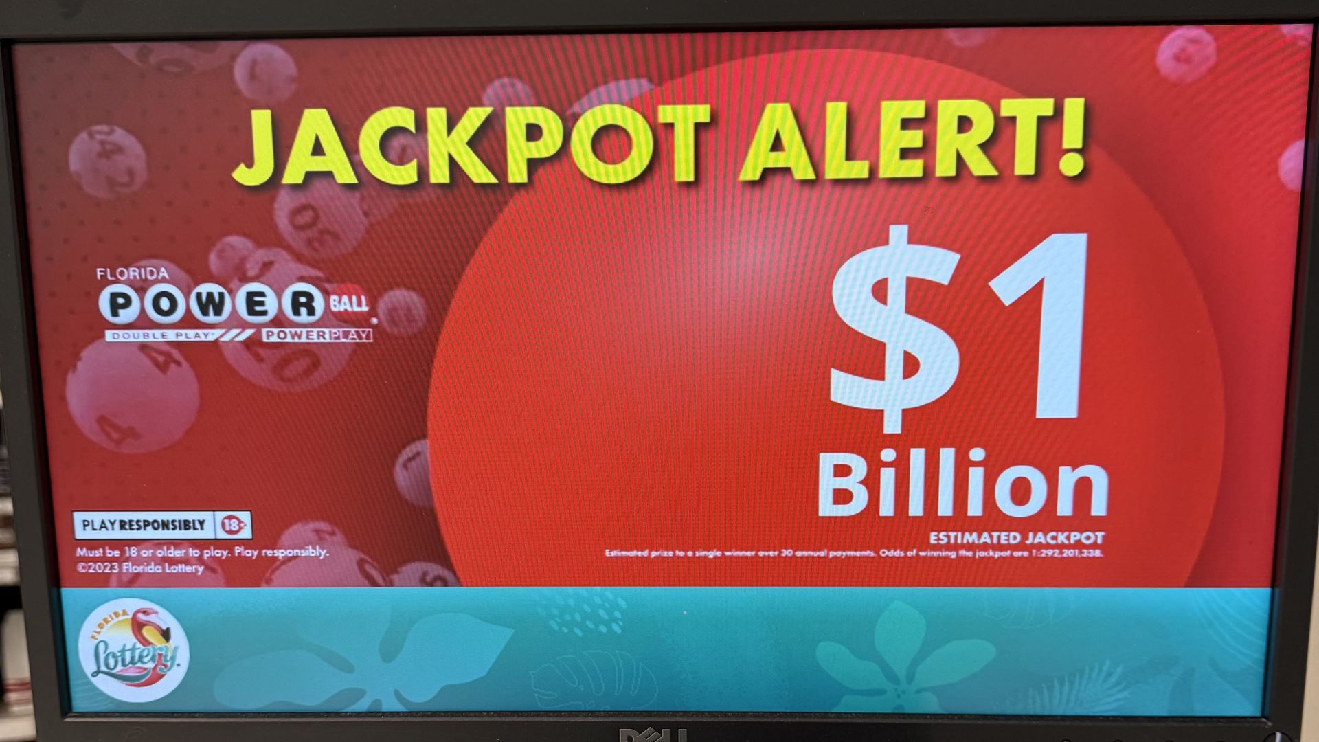Computer screen showing Florida Powerball jackpot alert with $1 billion estimated prize on red background, lottery logo, and draw times flyer below the screen.