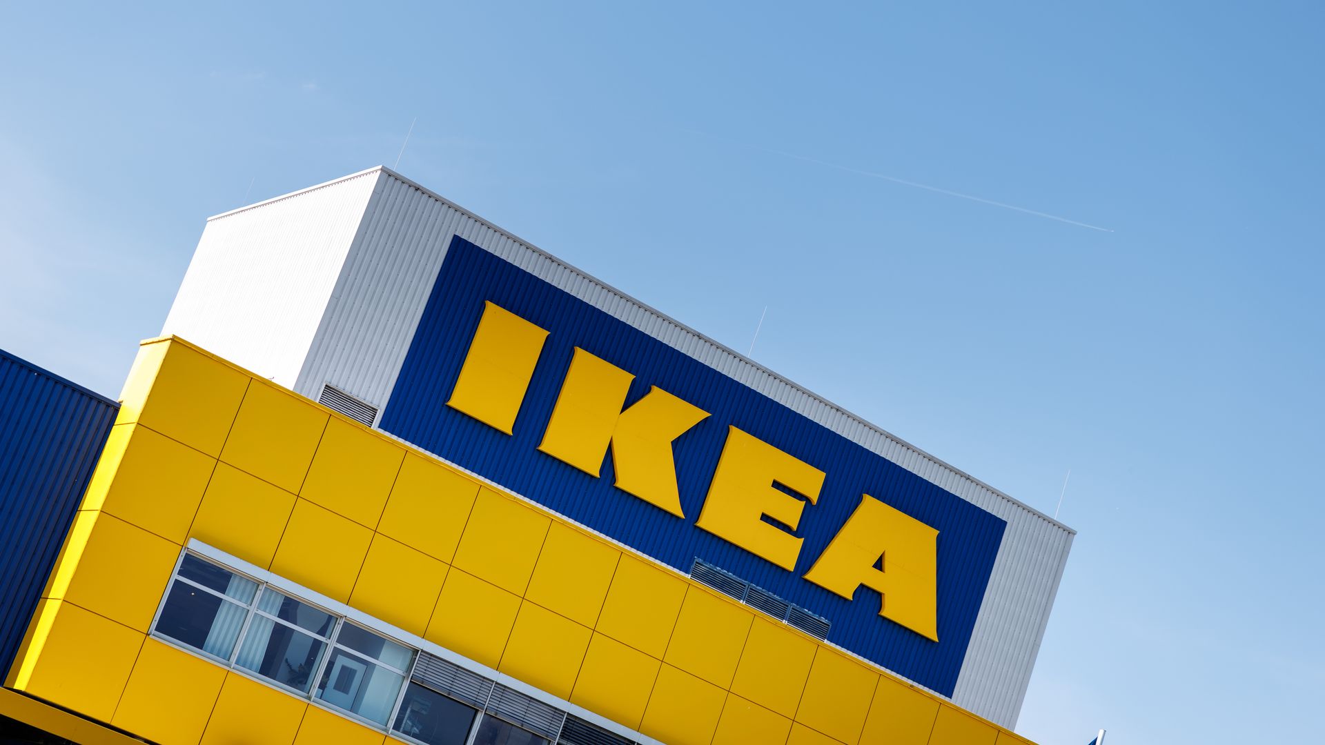 a photo shows the front of an IKEA store, showing the blue and yellow "IKEA" brand name. 