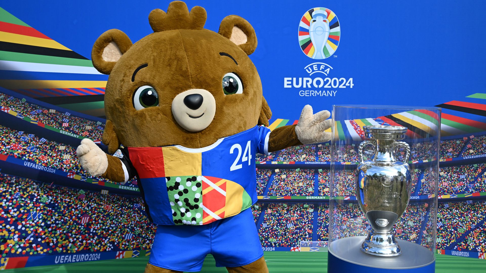 The UEFA Euro 2024 mascot poses next to a trophy mockup
