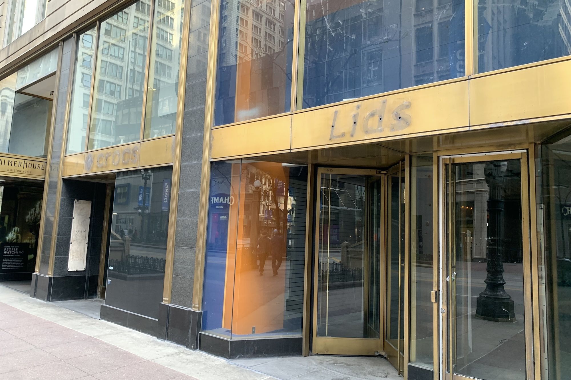 Outline of Lids store name on gold paneled building.