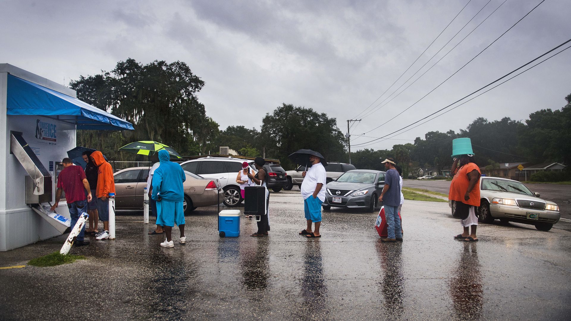 People wait in line to get ice from a vending machine