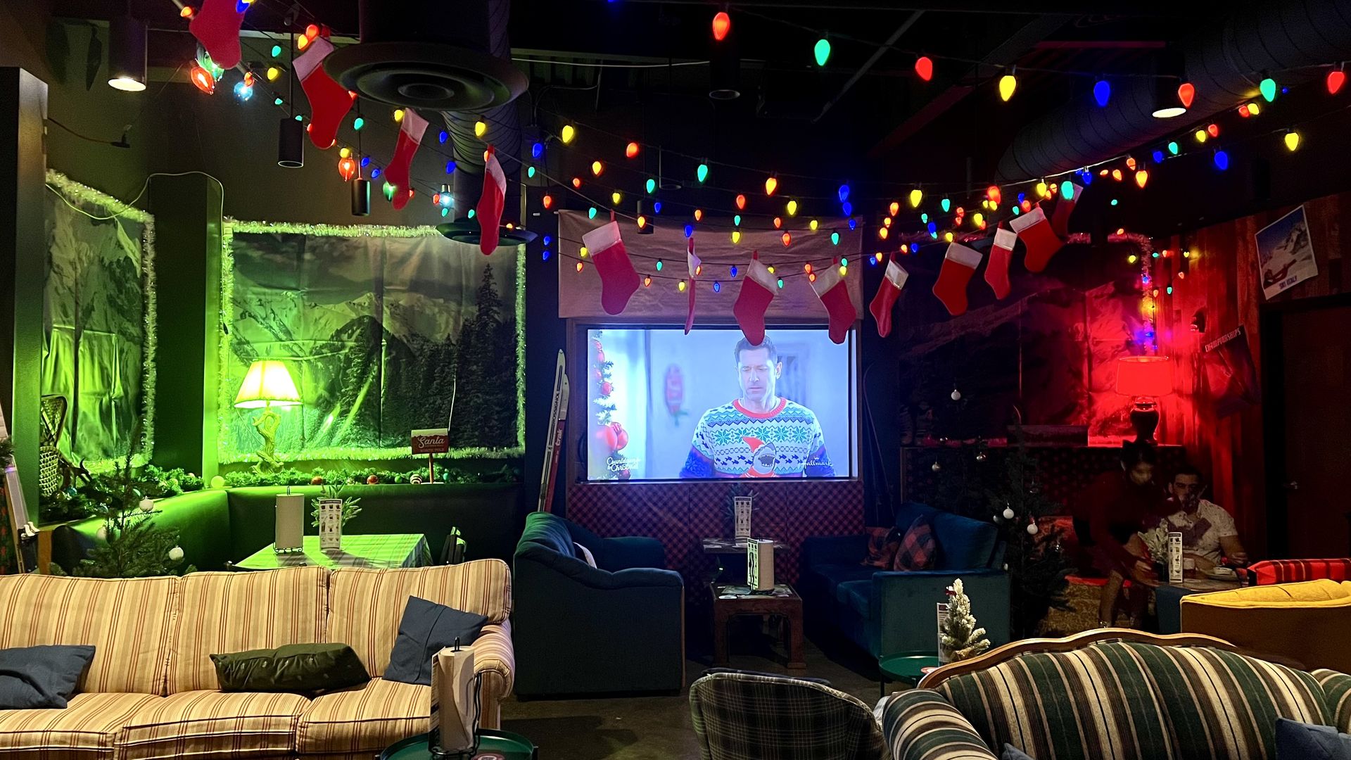 A living room style space decorated for Christmas.