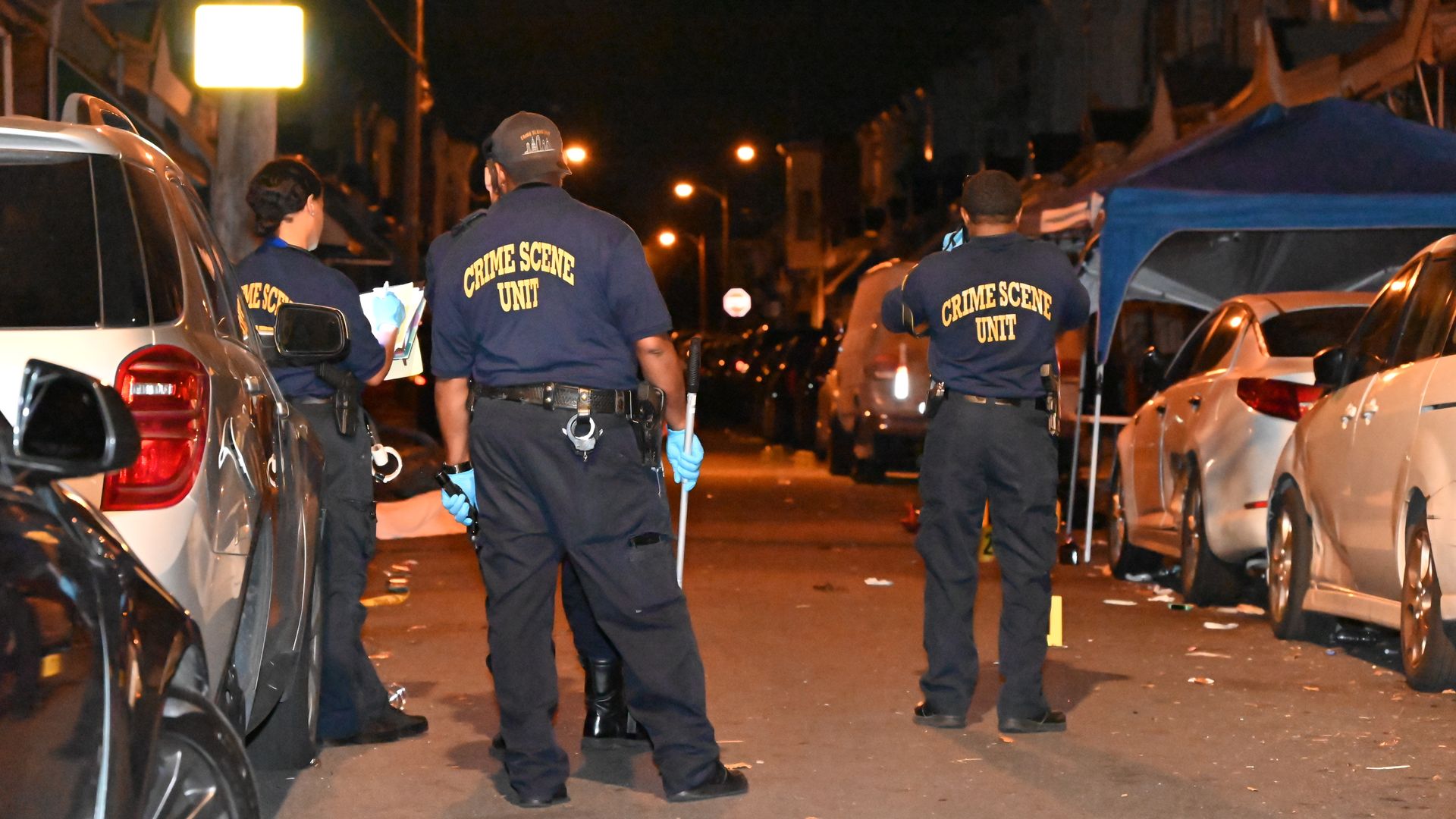 Crime scene unit at the scene of a mass shooting with evidence markers placed on the ground, after a mass shooting injured ten and killed three in Philadelphia in July 2024.