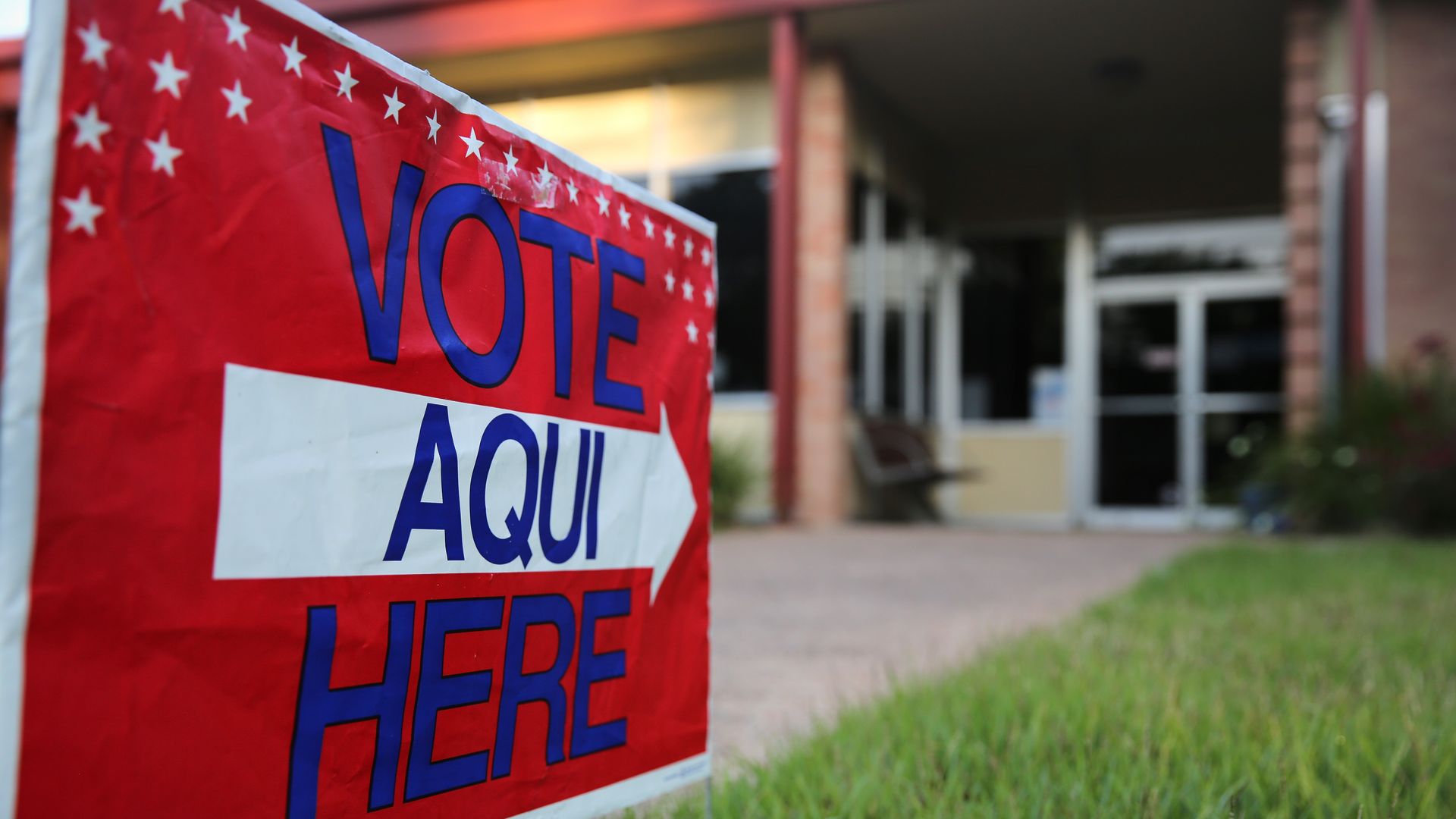 A bilingual sign stands outside a polling center at public library ahead of local elections in Austin, Texas.
