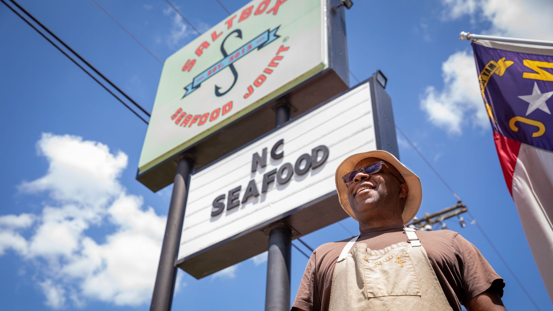 Ricky Moore stands in front of the Saltbox Seafood sign at his Durham restaurant.