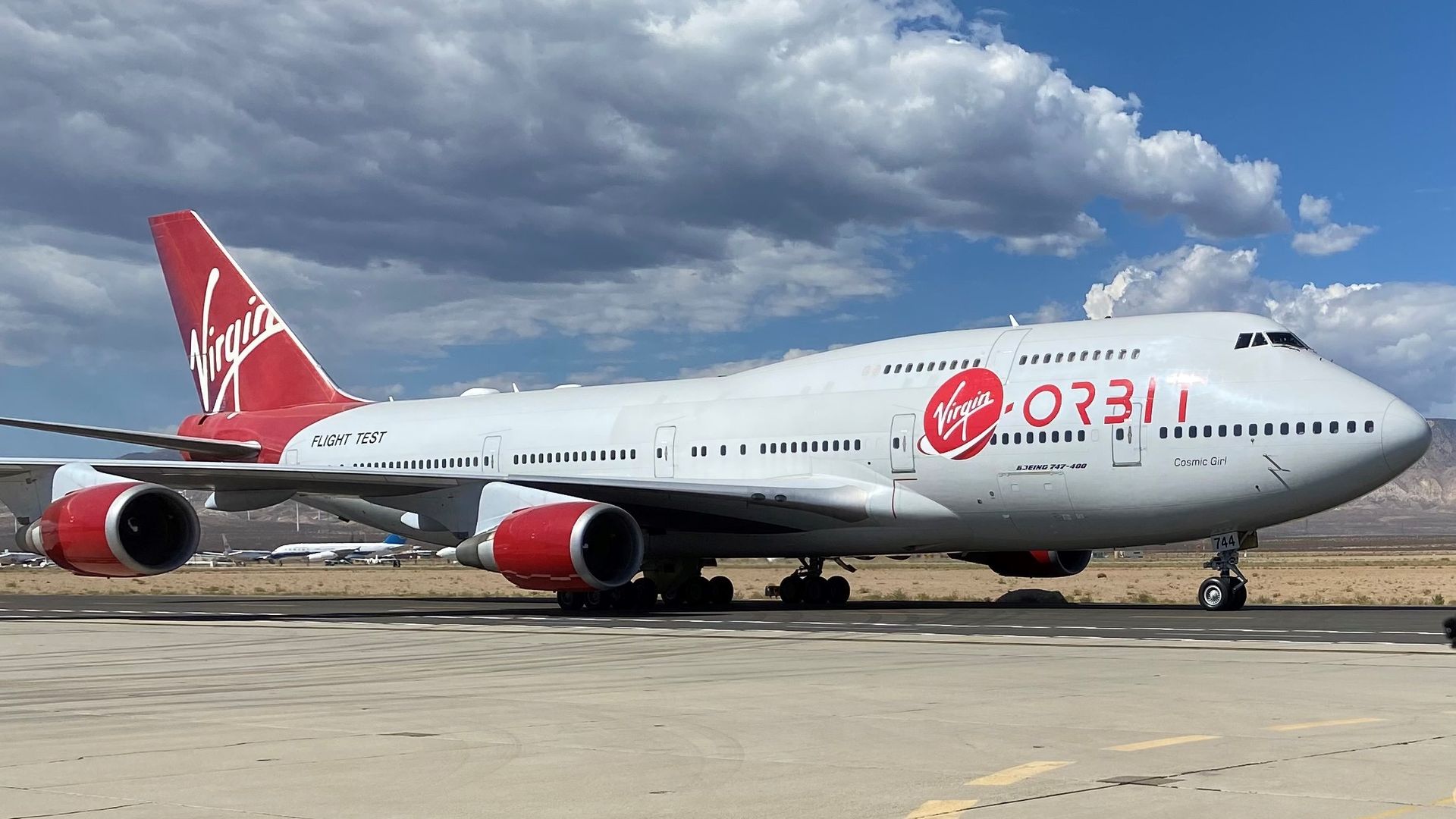 Virgin Orbit's Cosmic Girl on a tarmac with blue skies behind it.