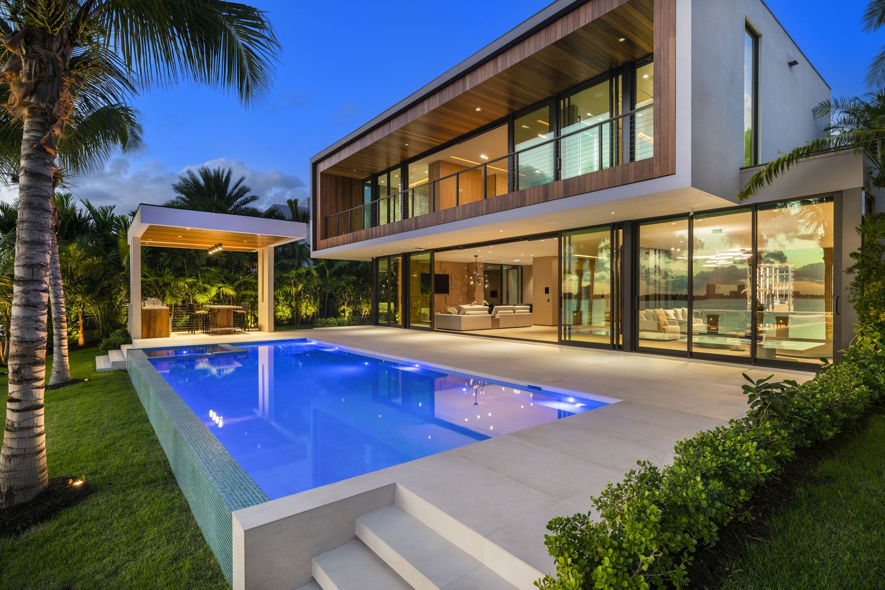 The backyard of a Bay Harbor Islands mansion, featuring a pool deck and wet bar.